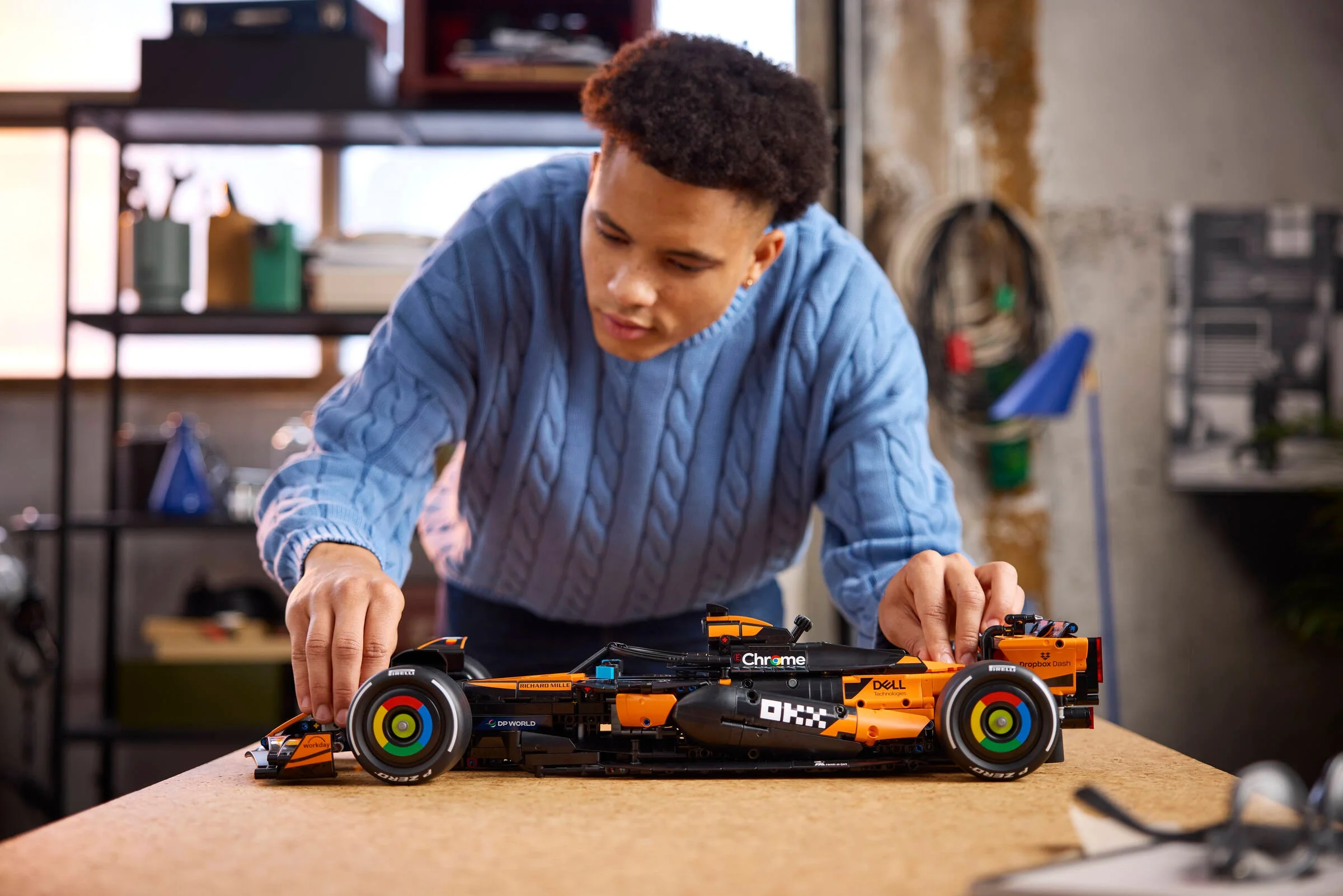 Un tânăr construiește modelul McLaren F1 MCL39. Atenție la detalii, pasiune pentru curse.