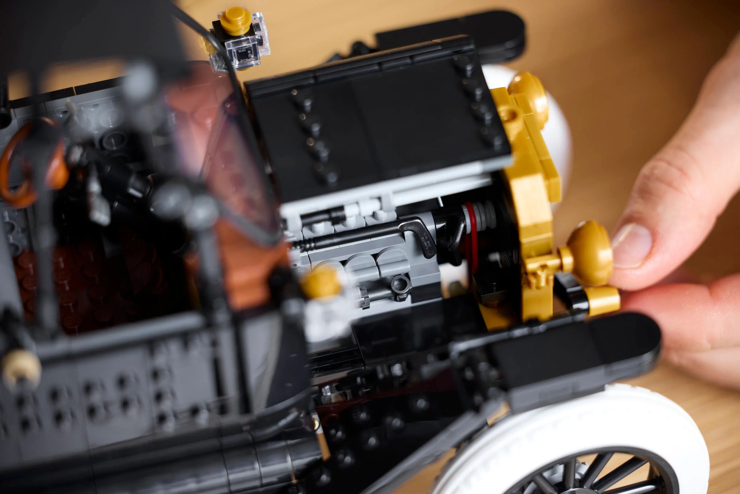 Detalii ale motorului Ford Model T LEGO, cu elemente funcționale expuse. 