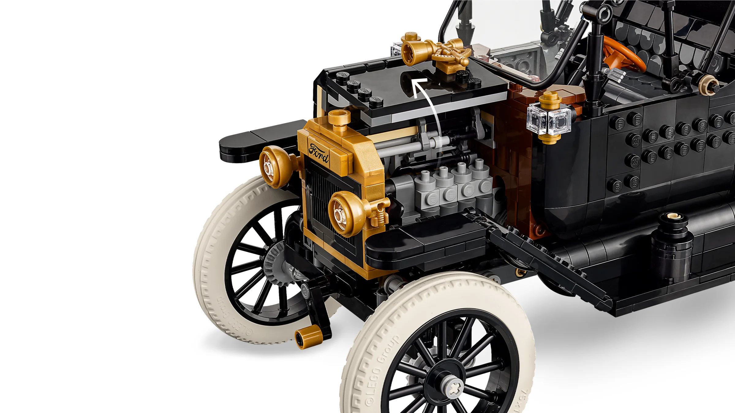 Detalii de aproape ale motorului Ford Model T, cu finisaje aurii și gri.