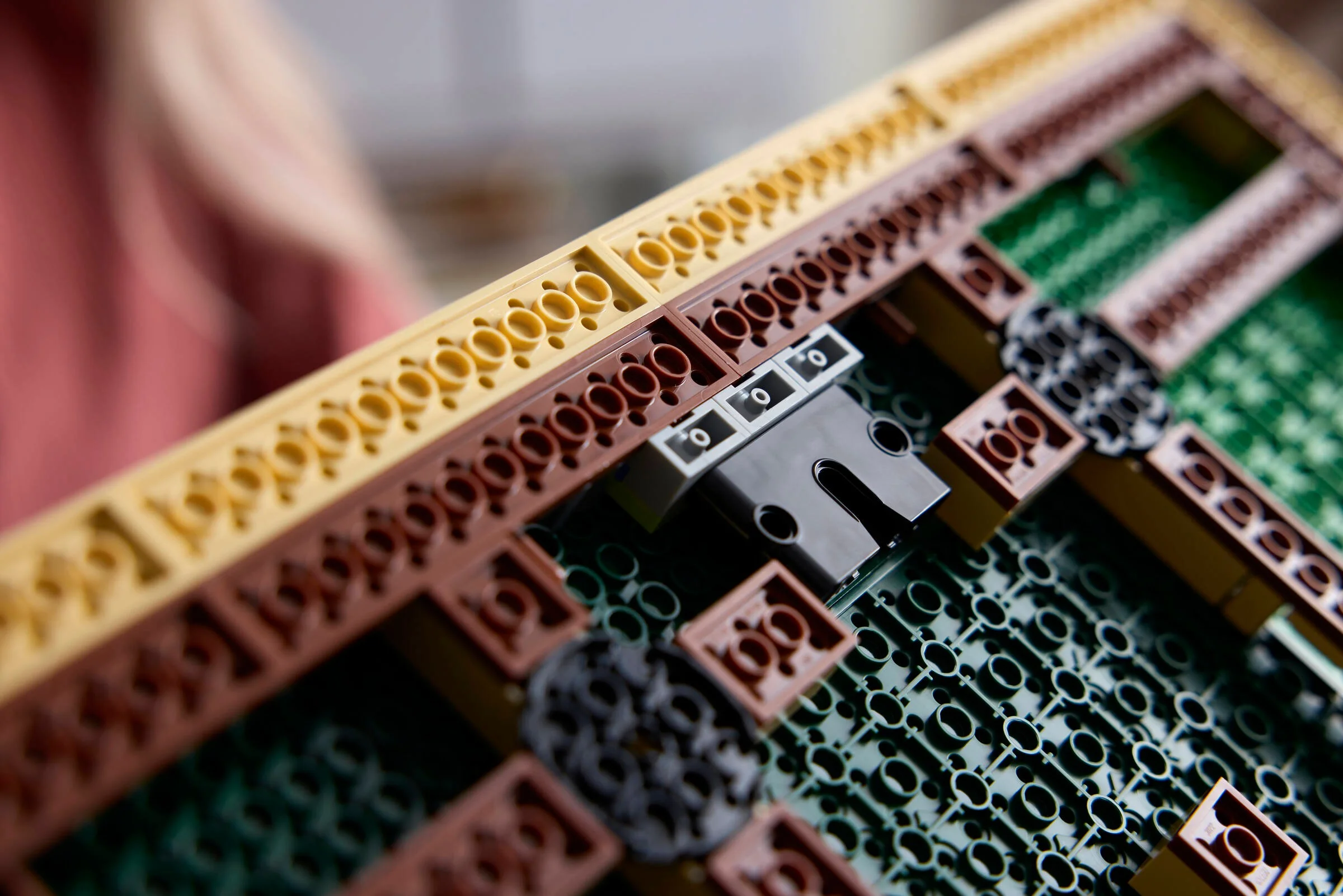 Detalii ale construcției LEGO Monet, cu cărămizi galbene, maro și verzi.