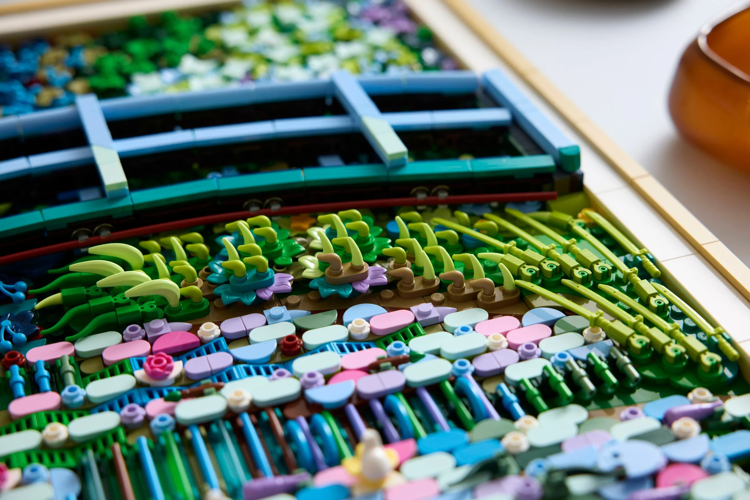 Prim-plan detaliat al podului și nuferilor, construit din piese LEGO colorate.
