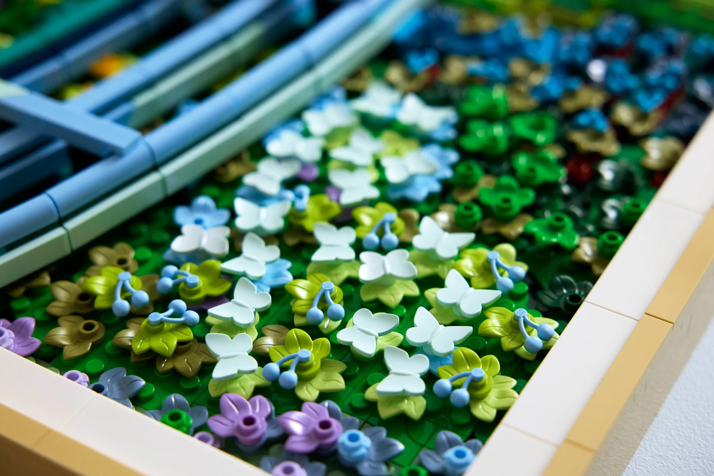 Prim-plan al detaliilor setului LEGO cu nuferi și pod, o reproducere artistică vibrantă.