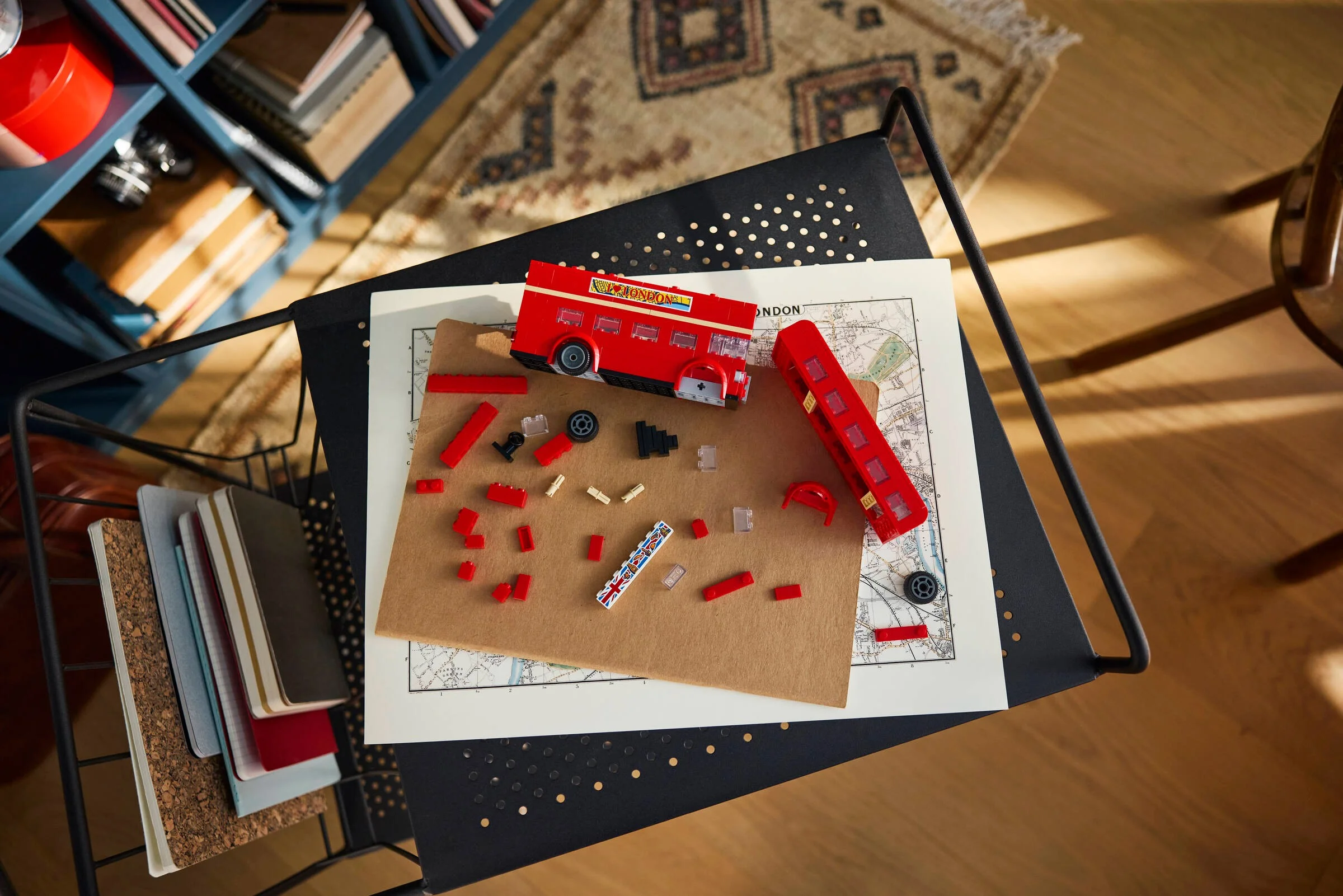 Autobuzul londonez LEGO în construcție, cu piese împrăștiate. Model Creator detaliat.