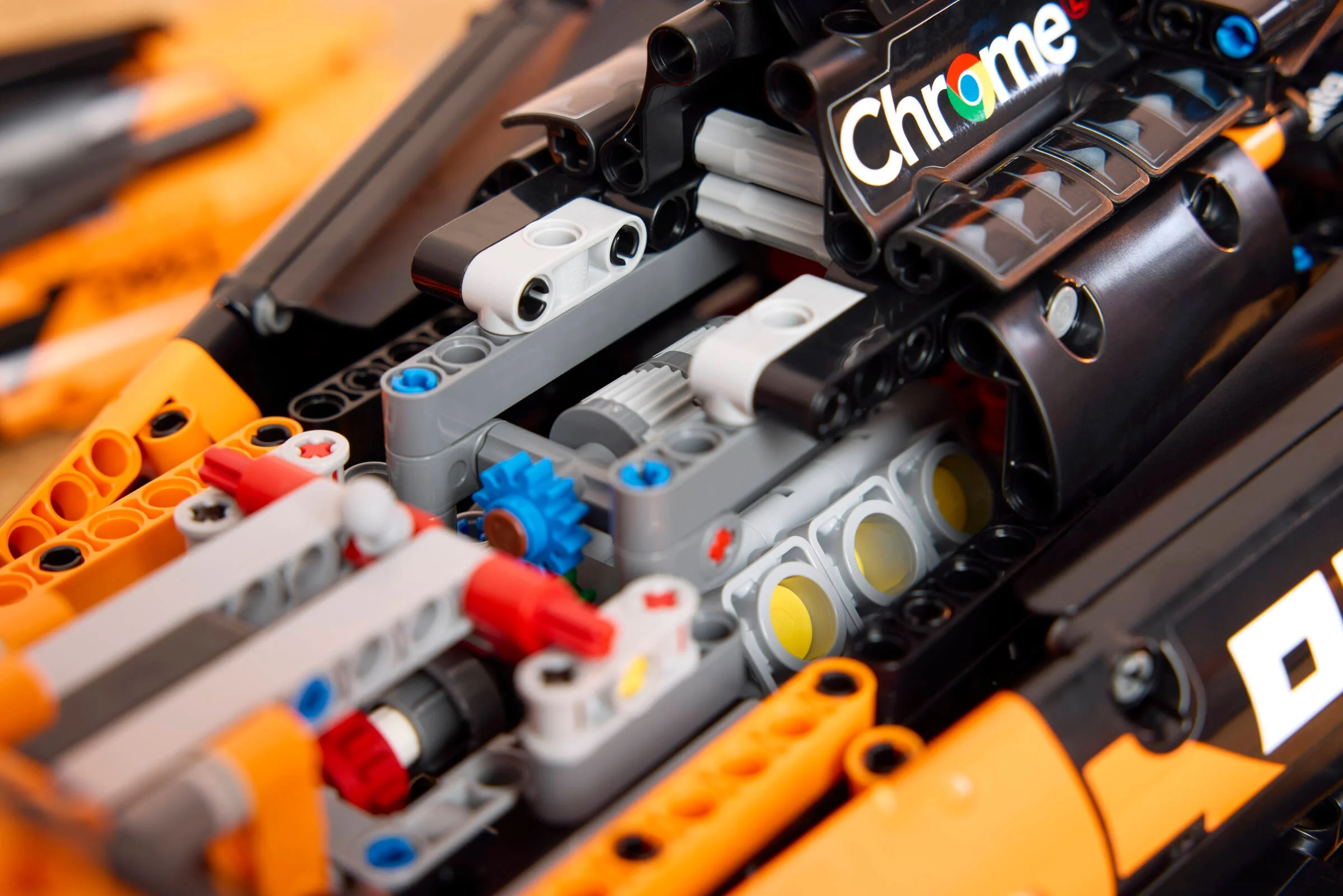 Prim-plan detaliat cu componentele Technic McLaren F1, inclusiv angrenaje și logo-ul Chrome.