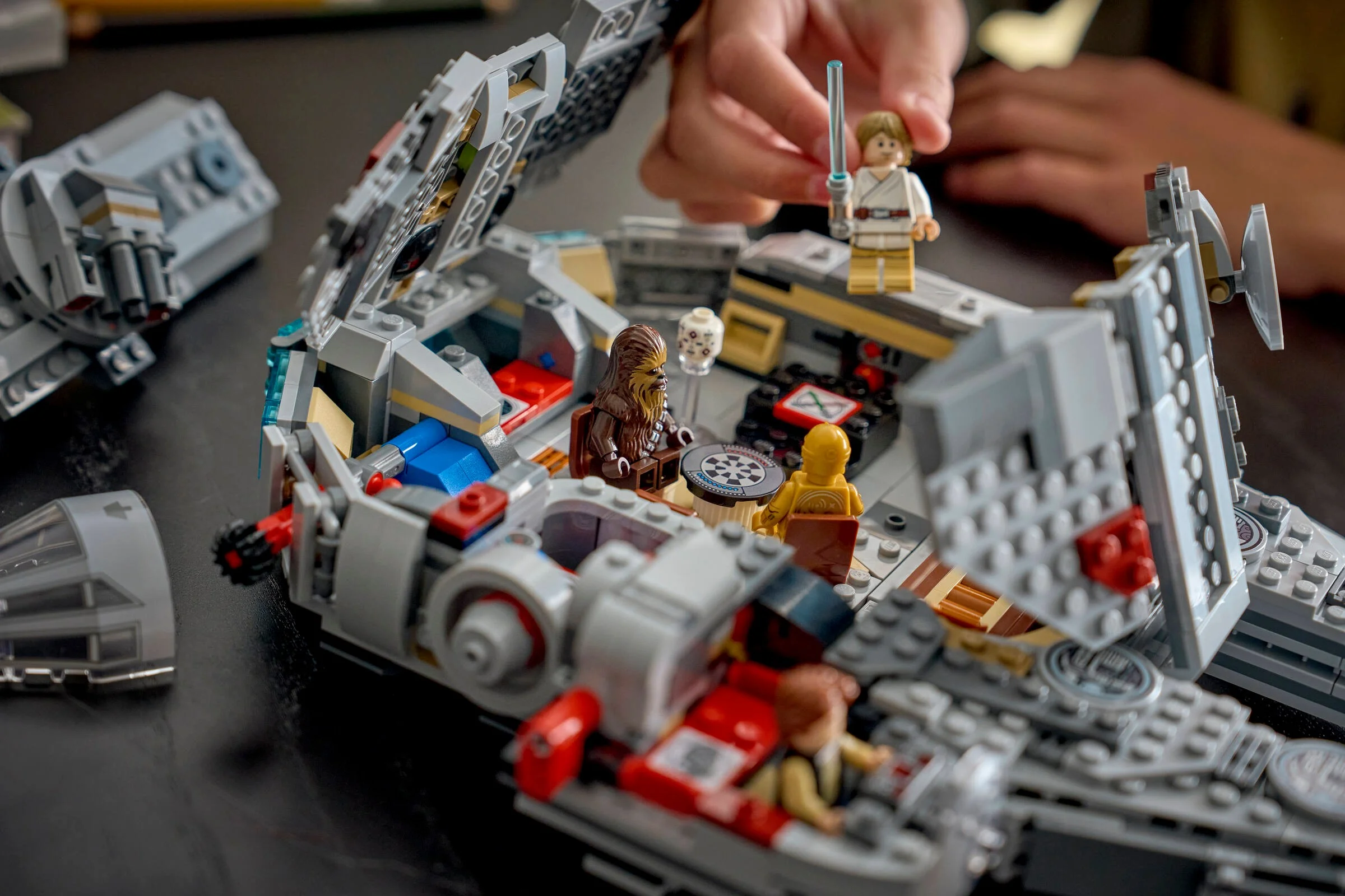 Interiorul detaliat al Millennium Falcon, cu minifigurinele Luke, Chewbacca și C-3PO.