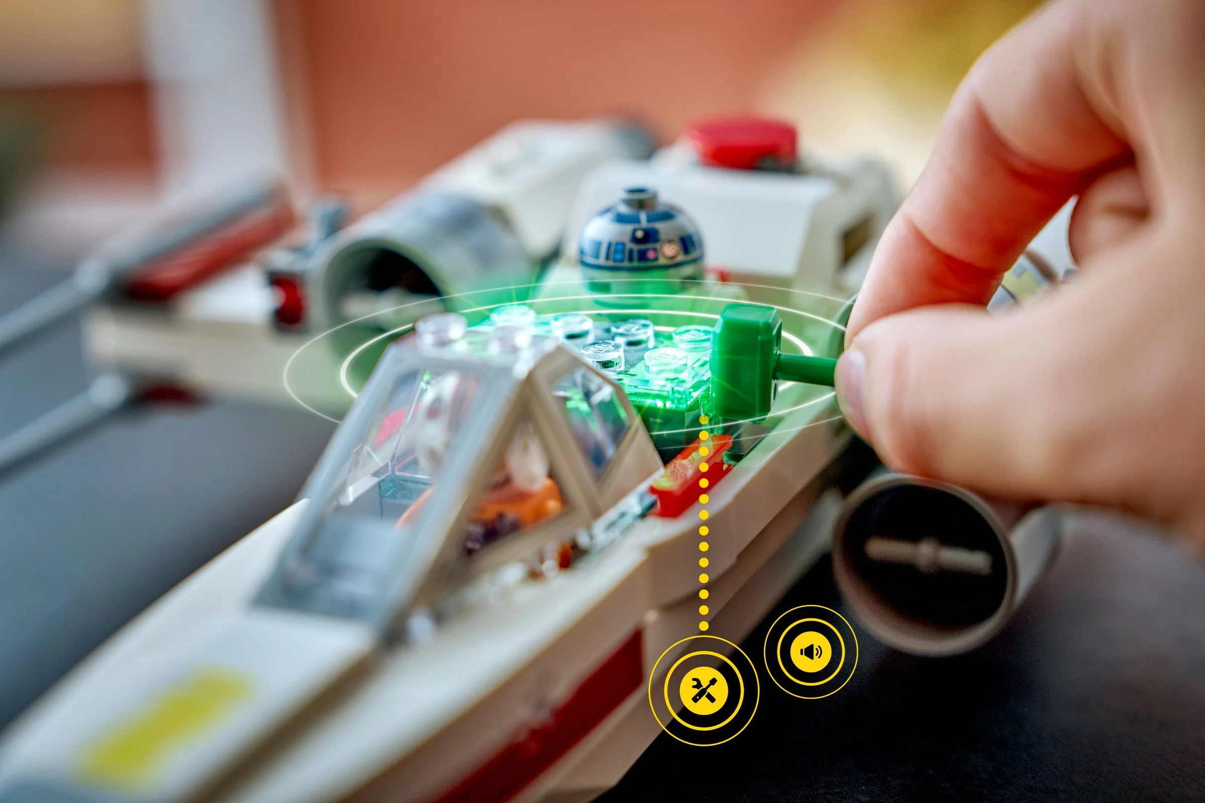 Detalii cu X-wing-ul lui Luke, mâna interacționând cu funcția de sunet și lumini.