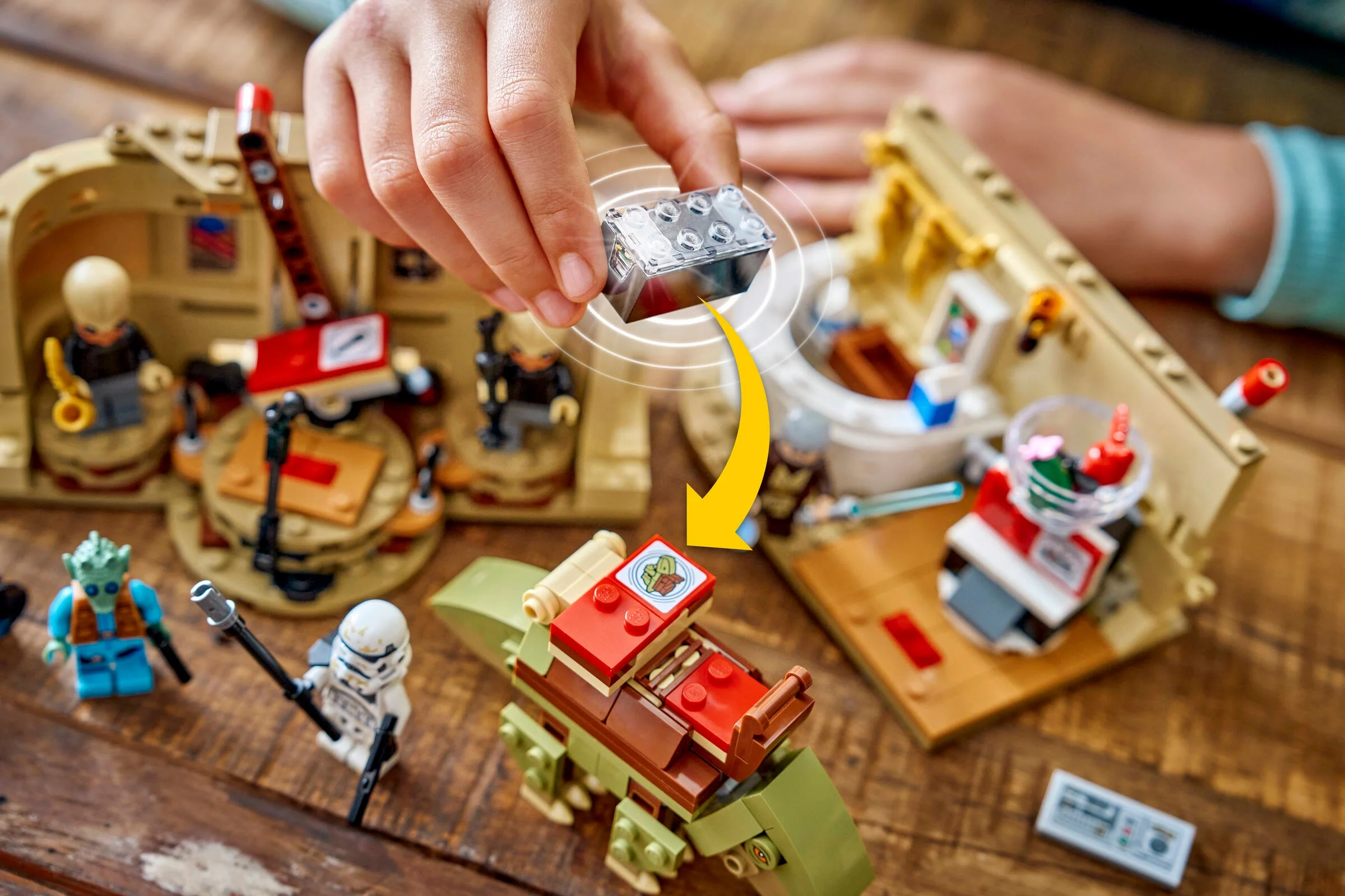 Construirea cantinei Mos Eisley: o mână adaugă o piesă importantă modelului LEGO.