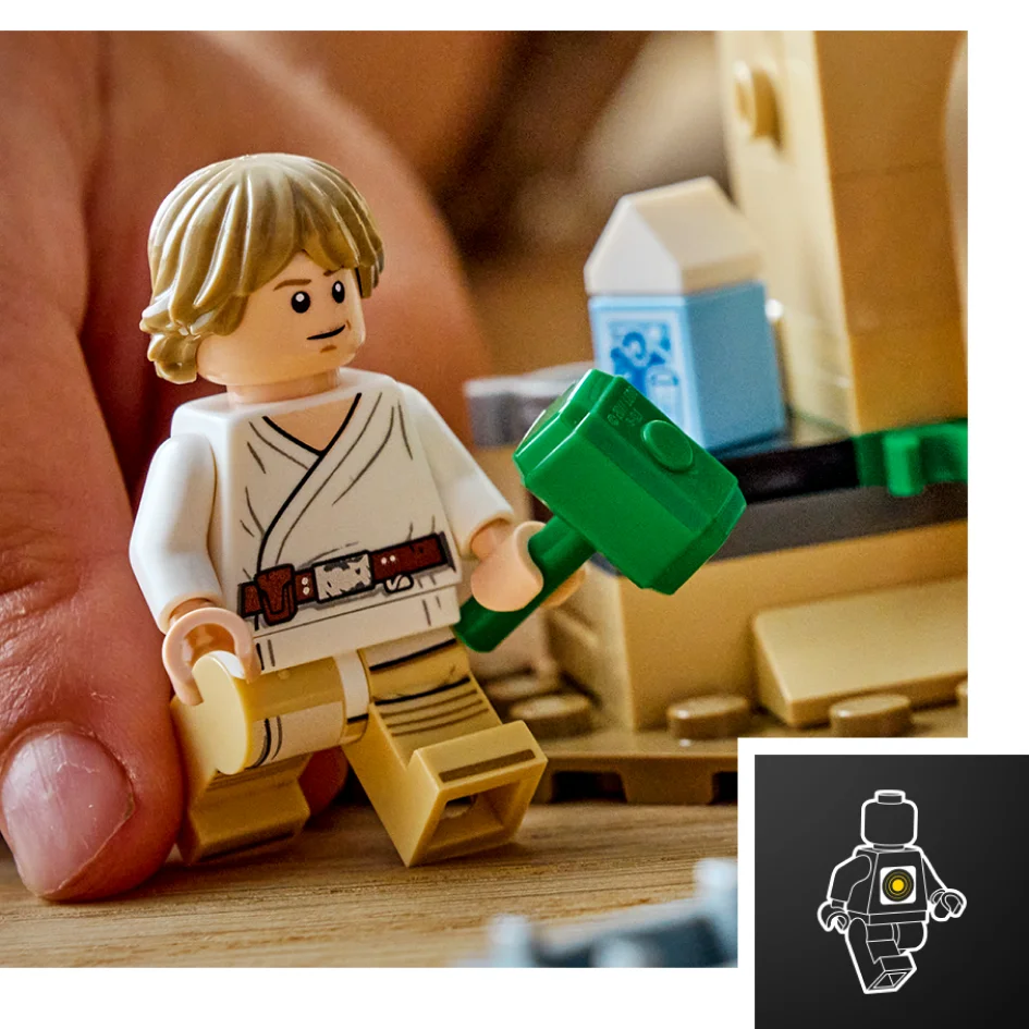 Prim plan cu minifigurina Luke Skywalker mânuind un ciocan verde, lângă un mic model LEGO.