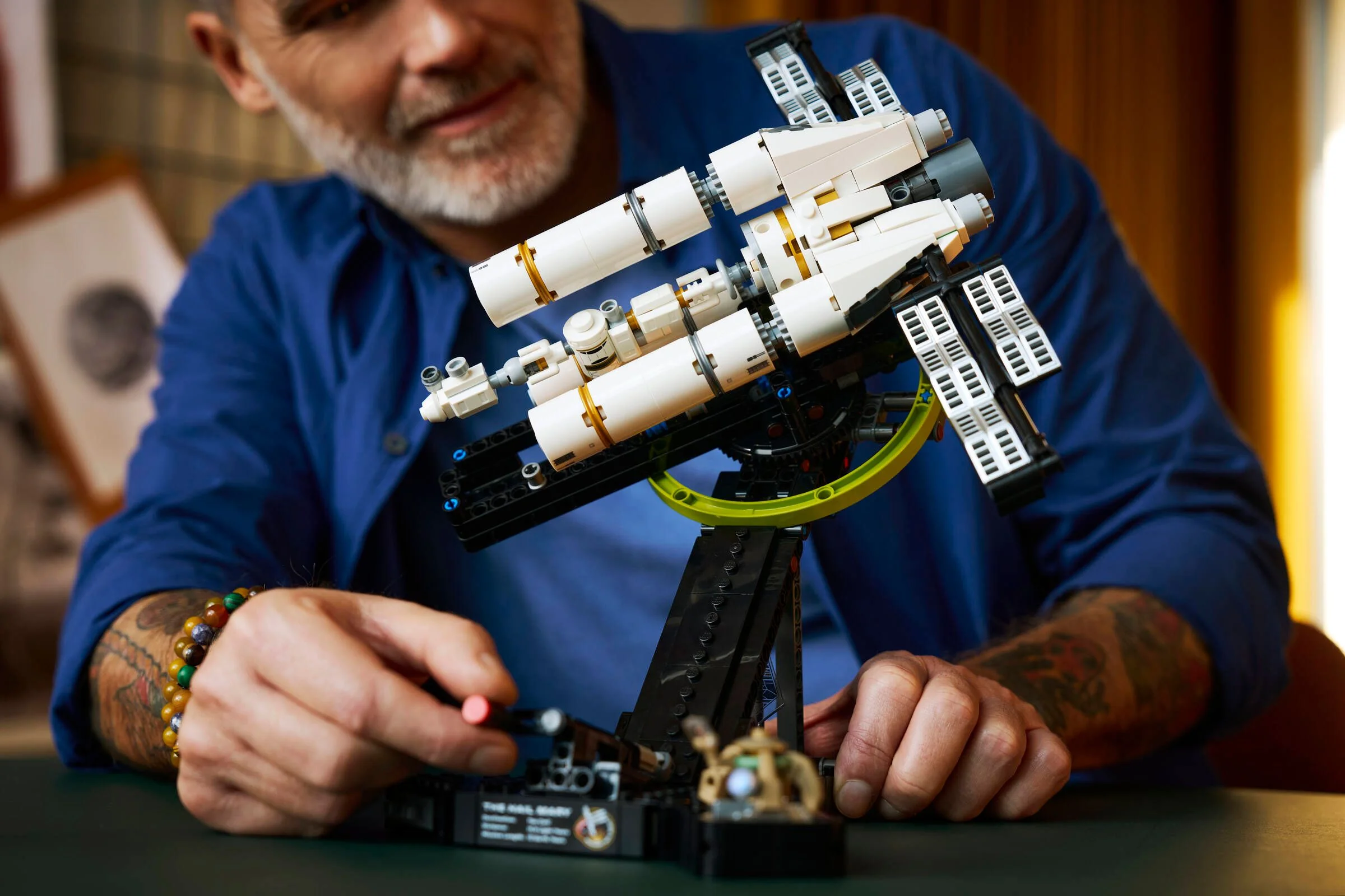 Un adult construiește macheta LEGO Project Hail Mary. Imagine detaliată.