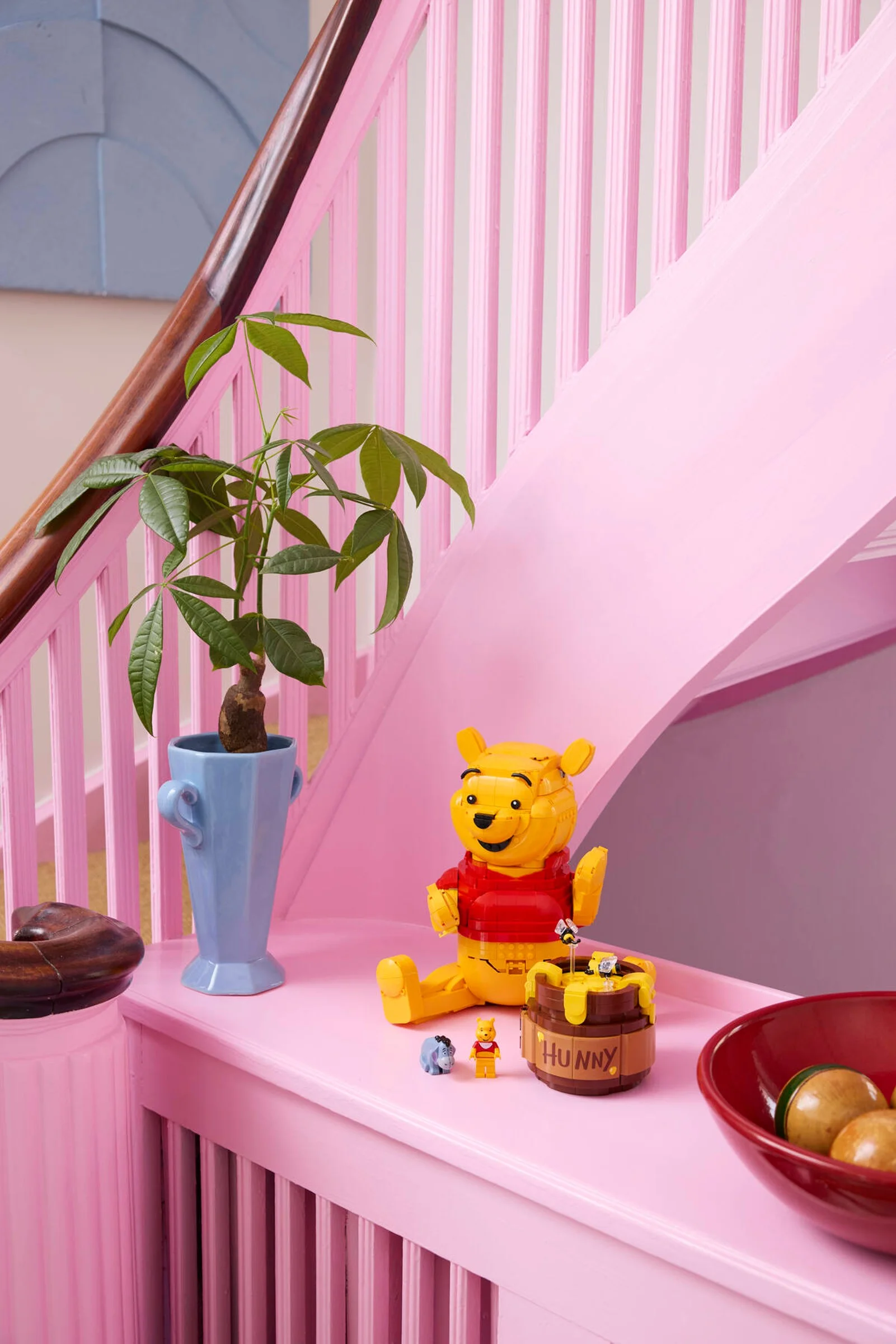 Imagine cu setul LEGO Winnie the Pooh (43300) pe un fundal roz. Aspect jucăuş, detaliat.