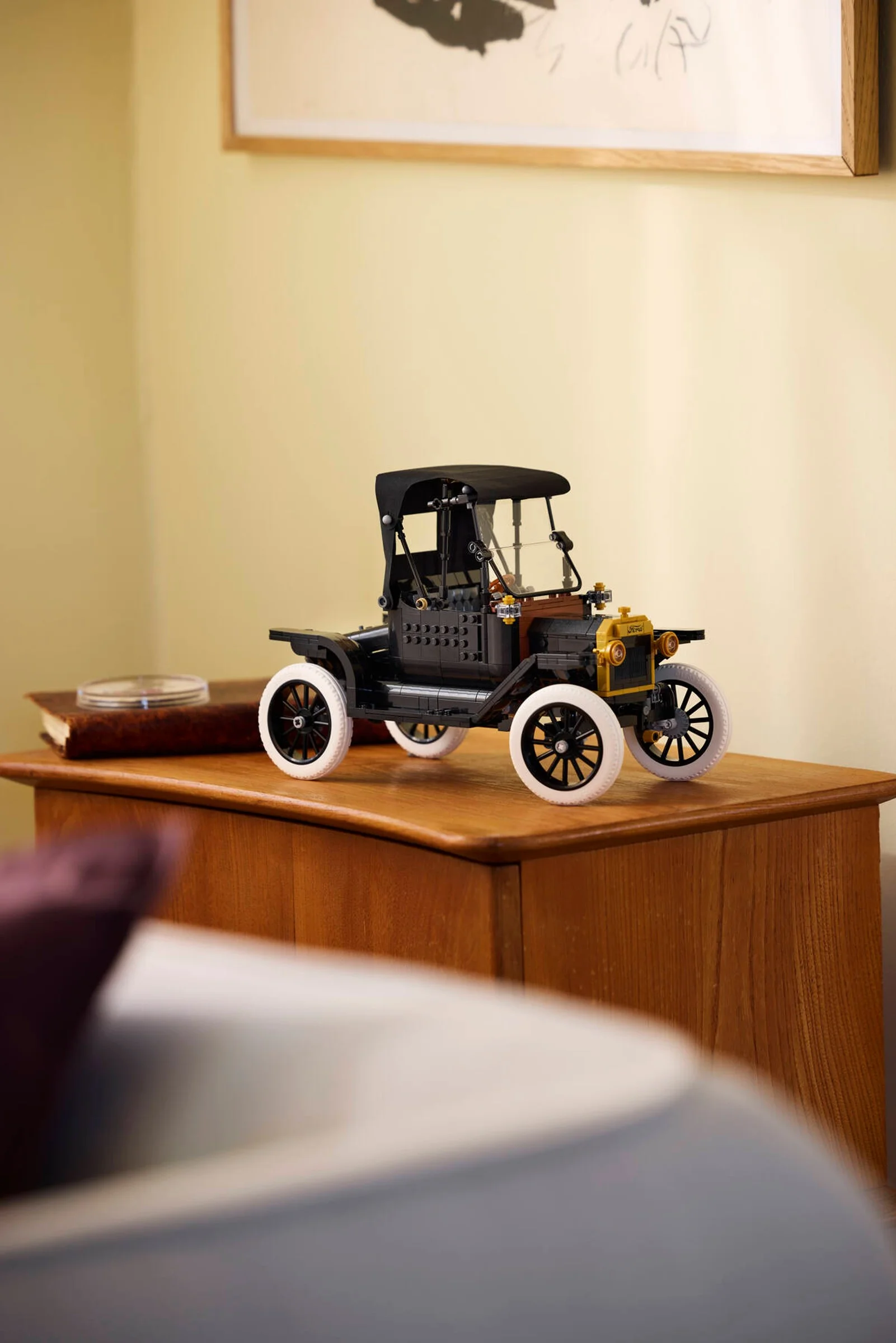 Imagine cu modelul Ford Model T, o mașină LEGO neagră cu detalii aurii și roți albe.