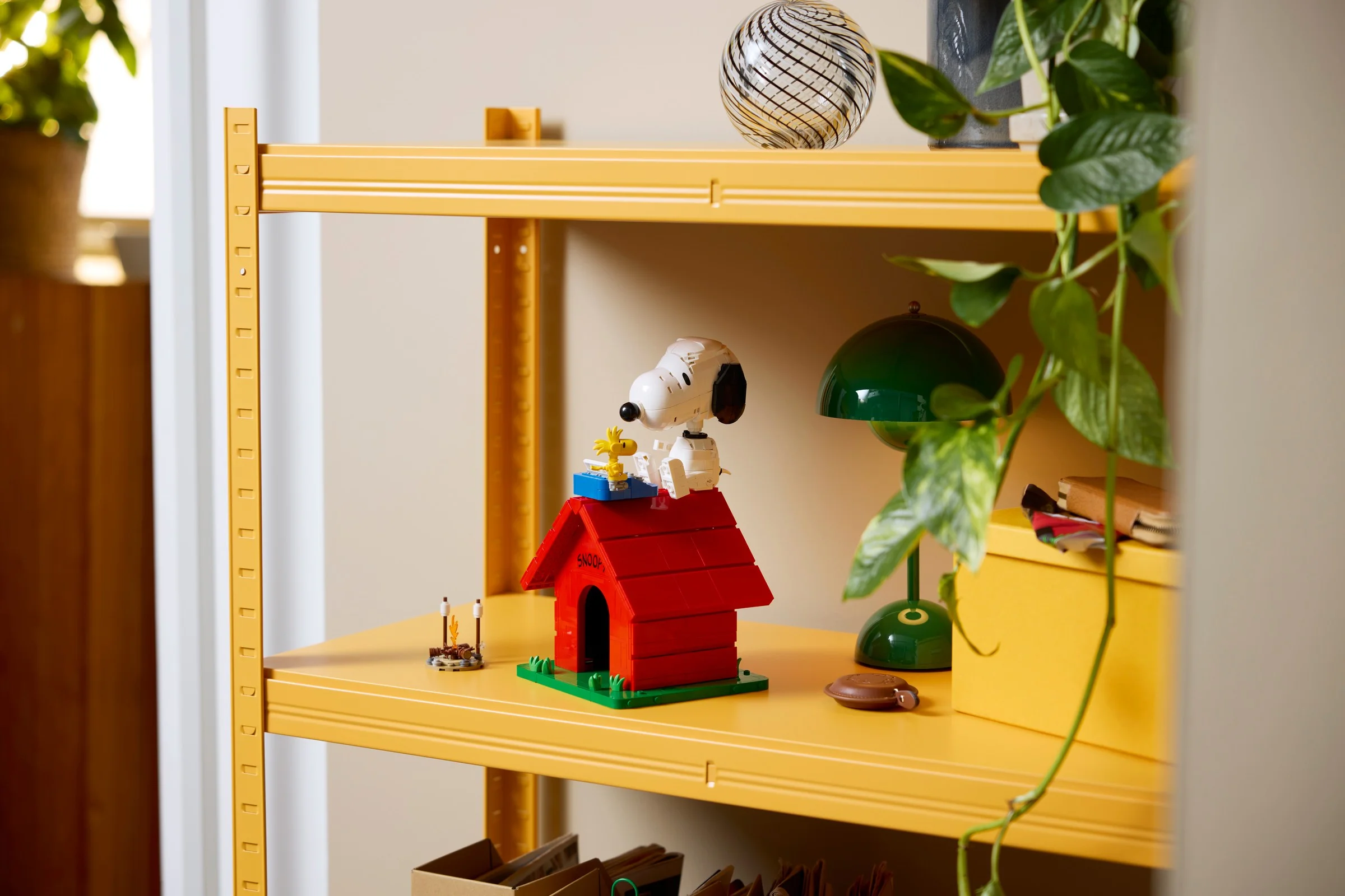 Snoopy și Woodstock pe căsuța sa LEGO, într-un cadru de prezentare modern și stilat.