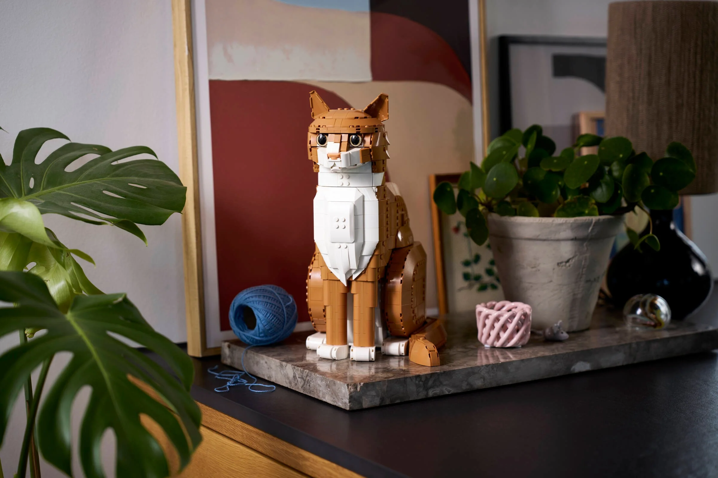 Prim-plan cu pisica portocalie LEGO Ideas 21376, așezată, cu detalii realiste și expresive.