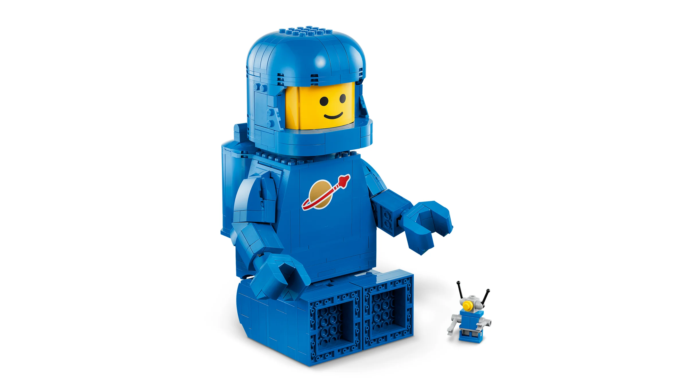 Imagine cu astronautul albastru LEGO mărit, cu un zâmbet și un mic robot. O jucărie nostaligică și atrăgătoare.