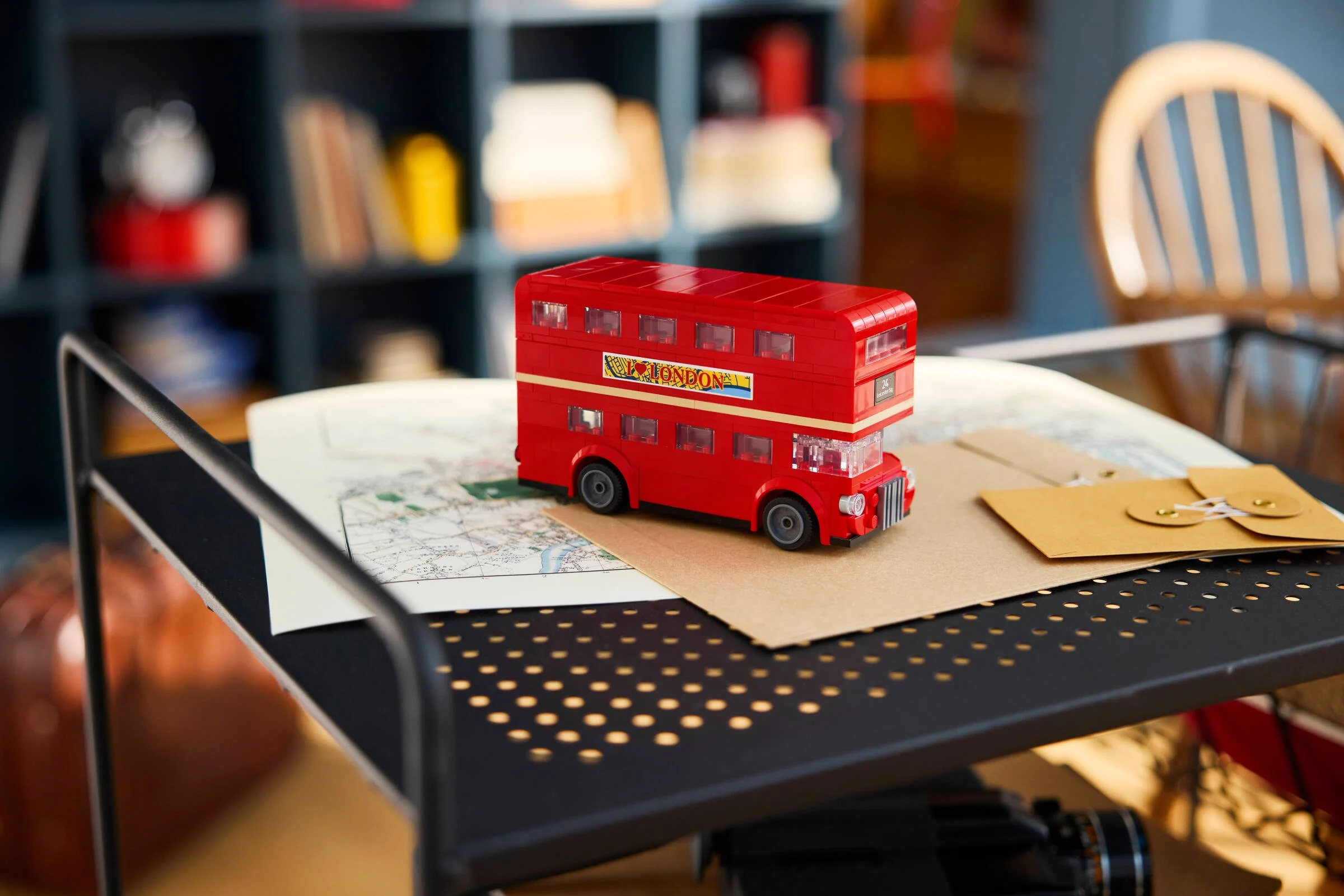 Autobuzul londonez LEGO roșu, un model detaliat, expus pe o hartă și plicuri.