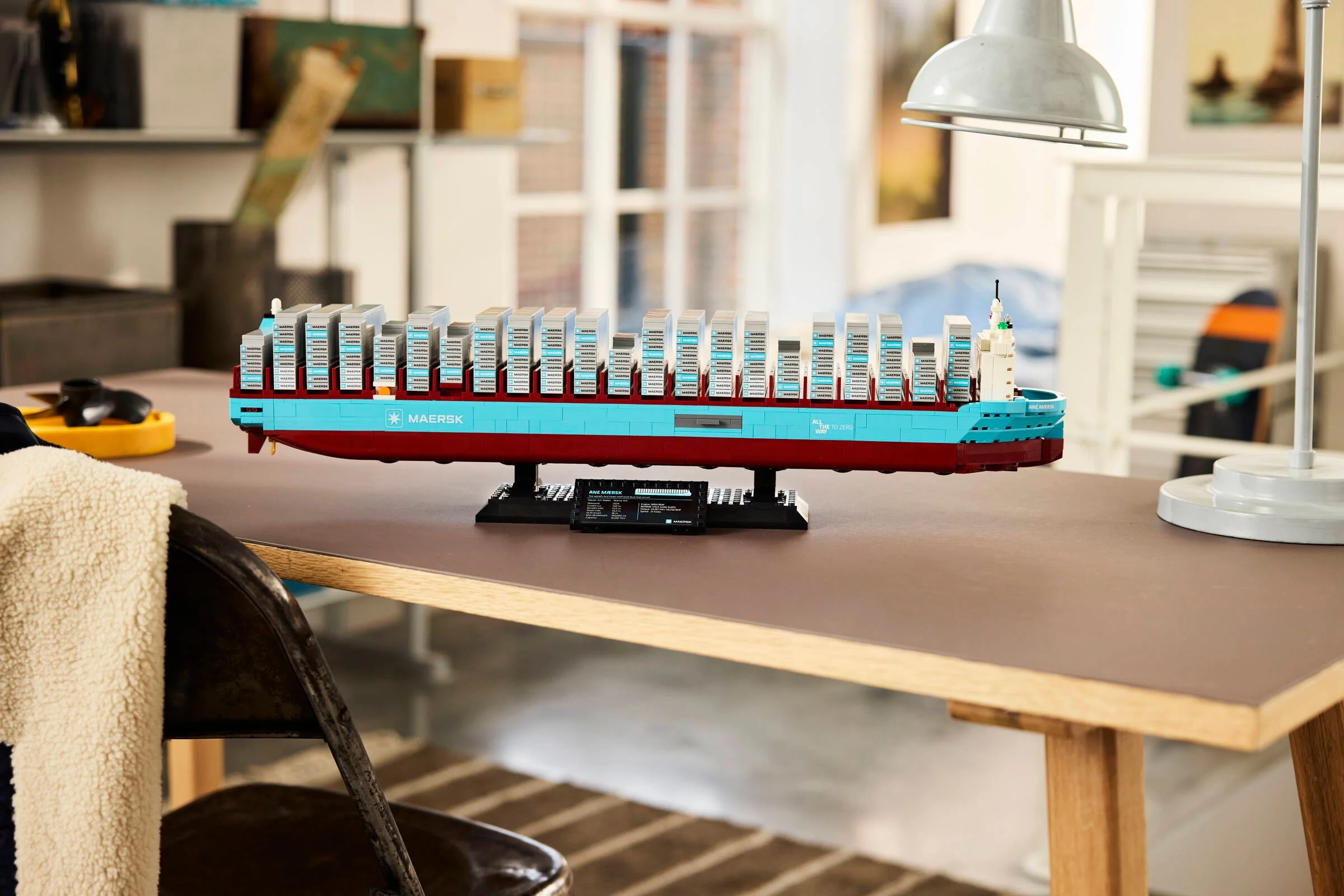 Modelul LEGO Maersk Dual-Fuel Container Vessel, o navă mare cu containere albastre și roșii.