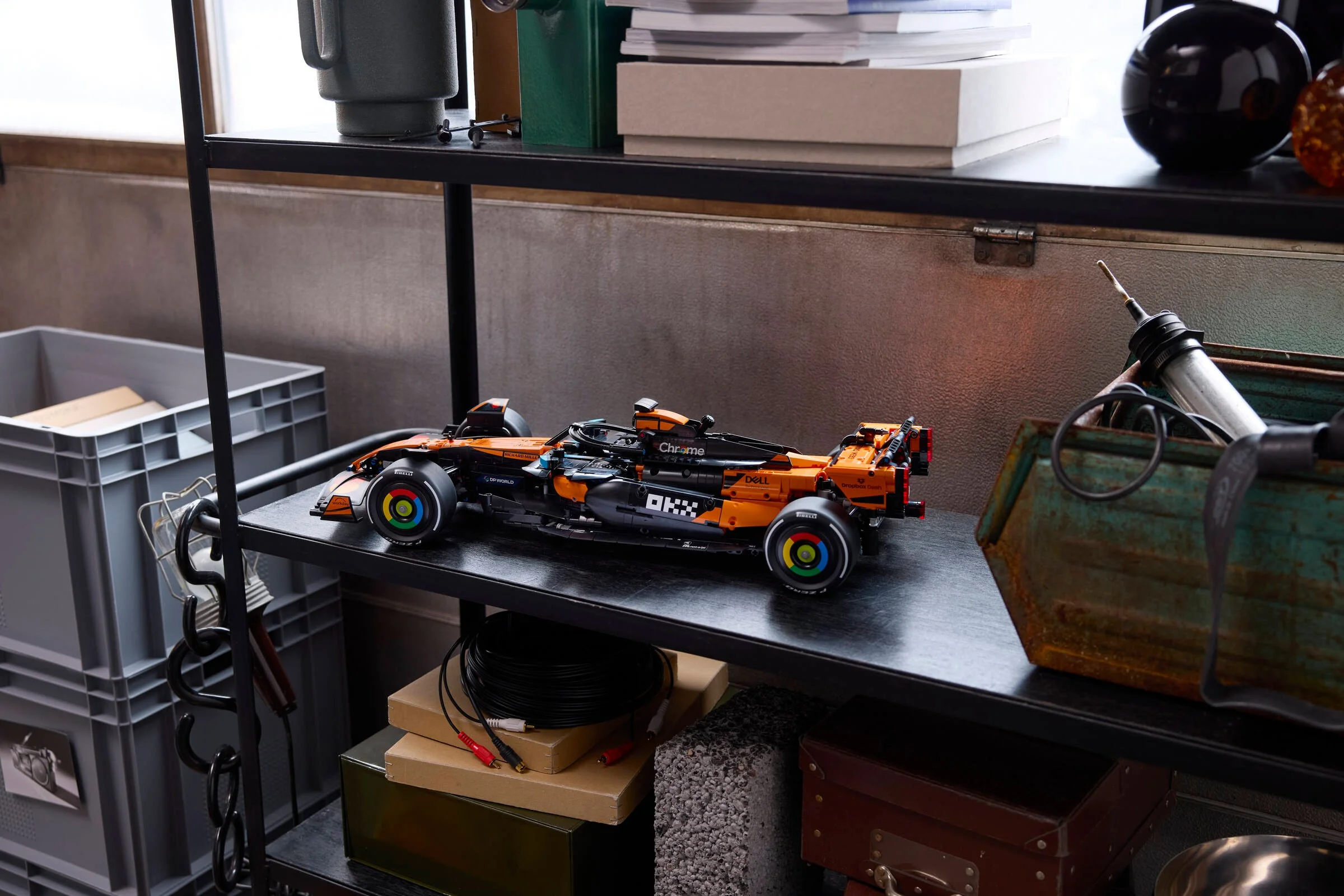 Modelul LEGO McLaren F1 MCL39 expus pe o etajeră, într-un cadru stilat, cu detalii de design.
