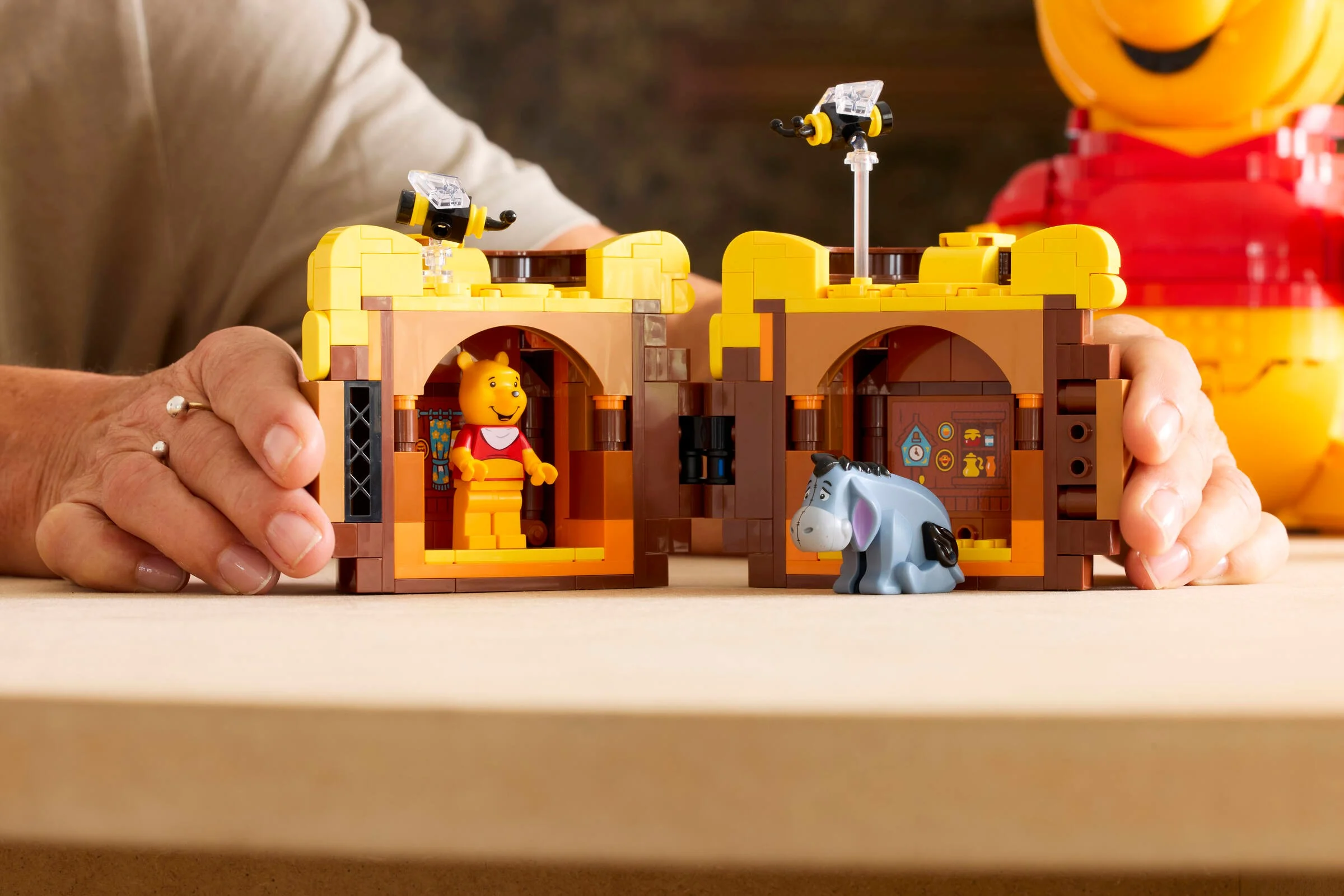 Imagine cu Pooh și Eeyore în casa lor LEGO, detaliată și plină de culoare.