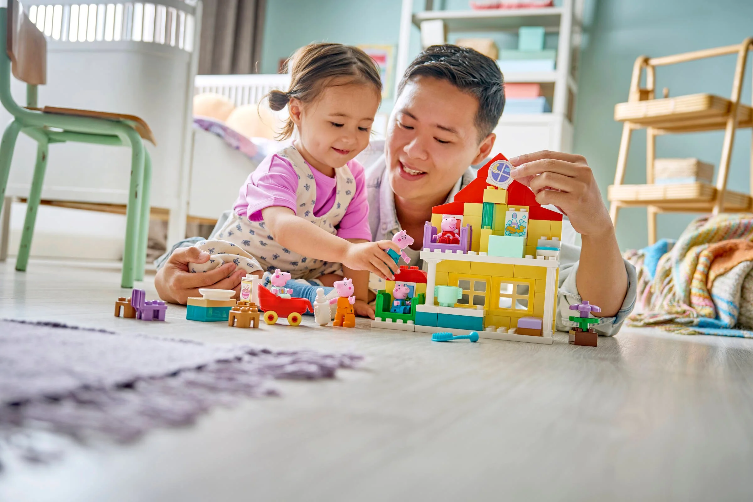 Tată și fiică construind casa Duplo, cu figurine Peppa Pig. Distracție și creativitate!