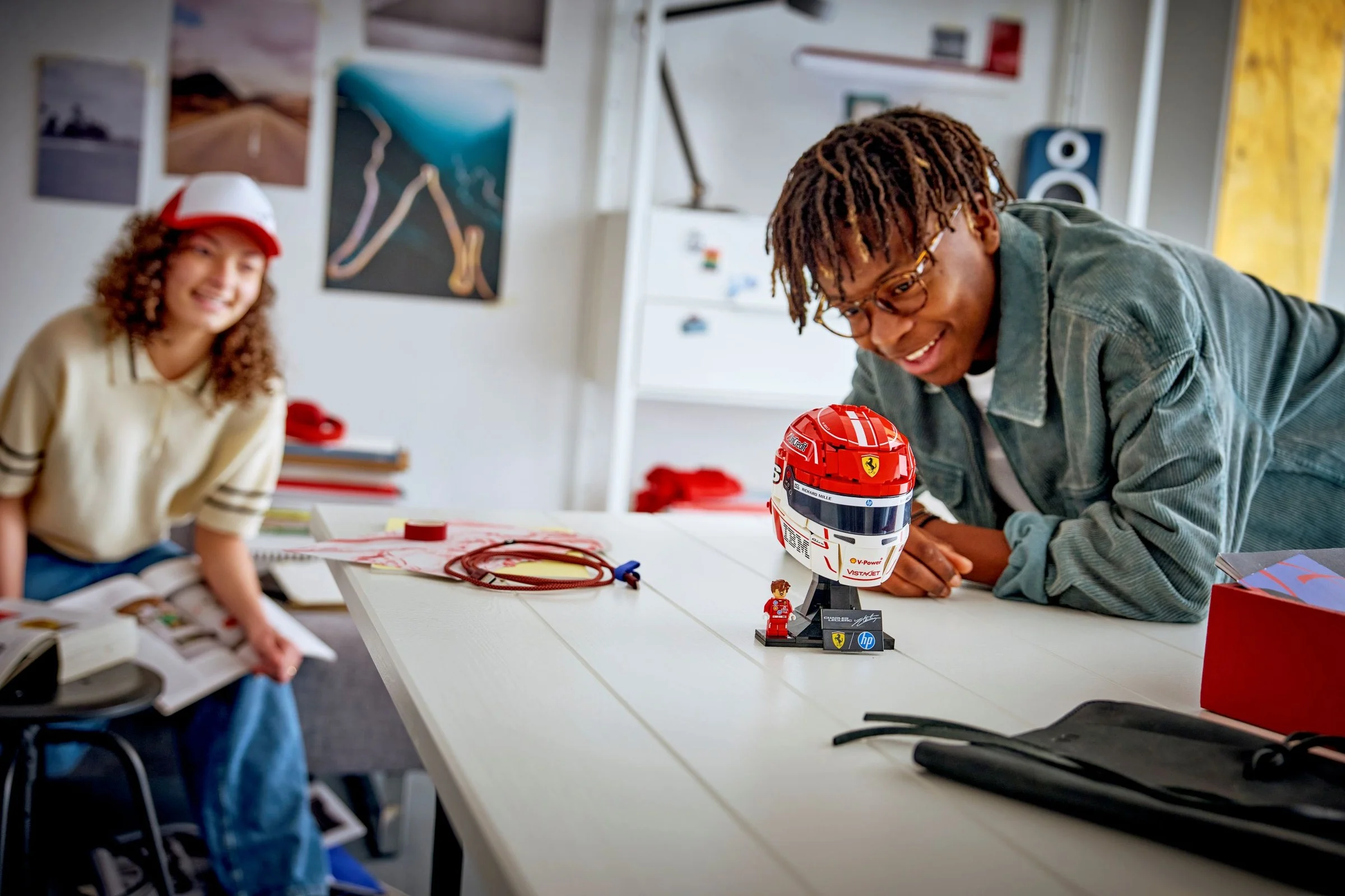 Tineri admirând casca Ferrari HP Charles Leclerc LEGO. O scenă de pasiune pentru Formula 1.
