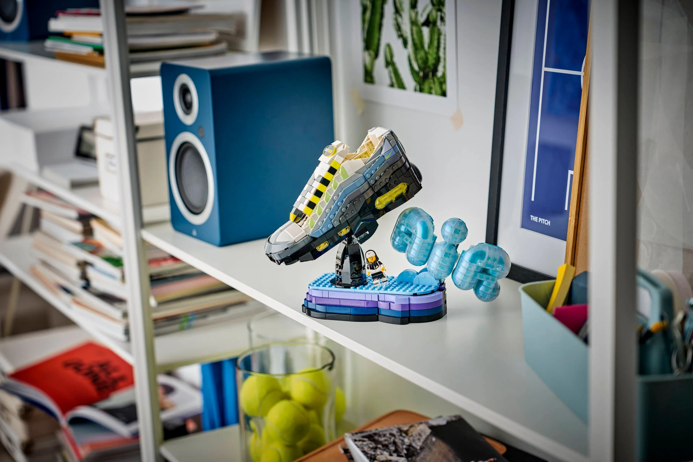 Modelul LEGO Nike Air Max 95 expus pe un raft, într-un decor cotidian. O piesă de colecție aranjată.
