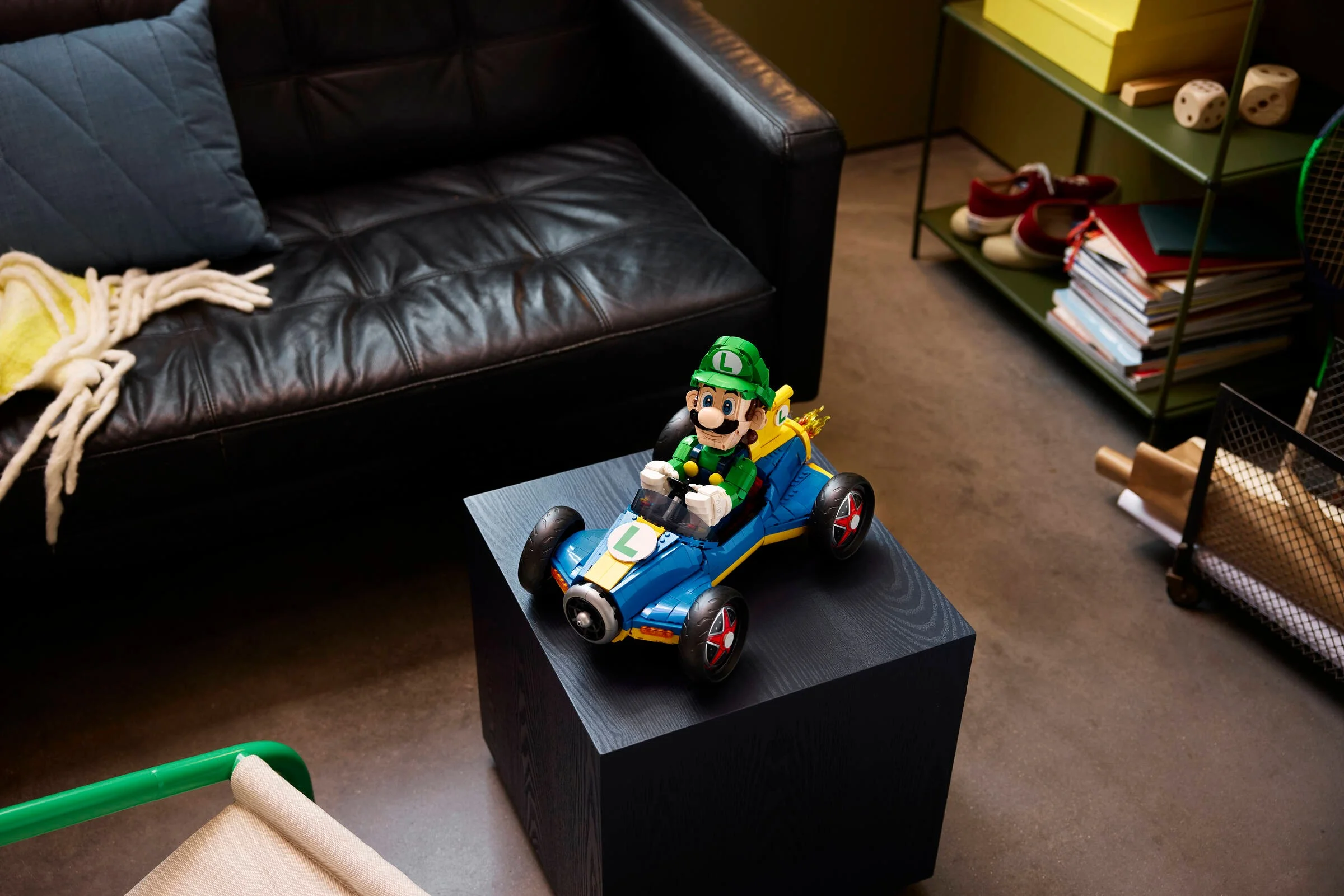 Luigi și Mach 8 LEGO pe o măsuță neagră, într-un cadru modern de living.