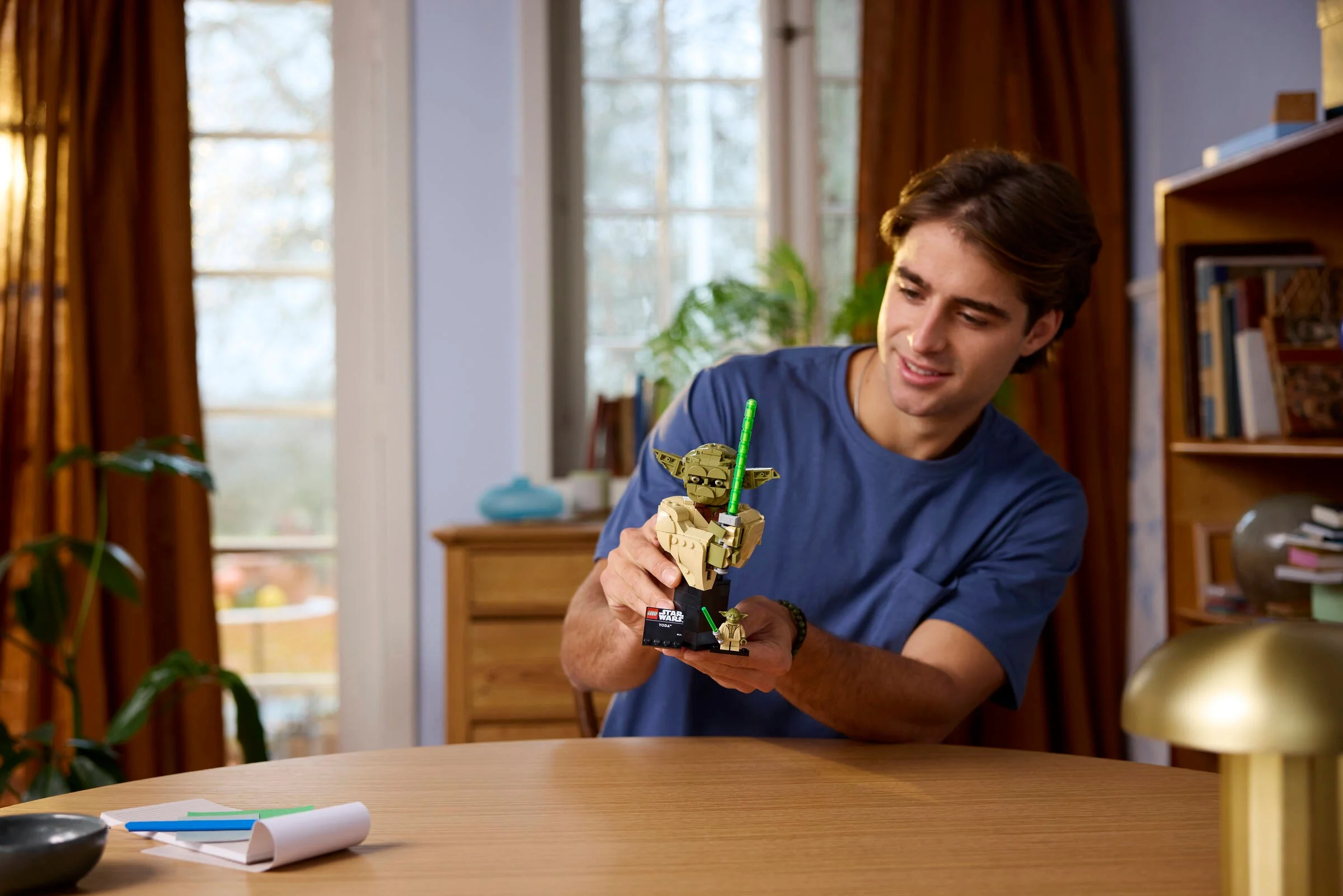 Bustul Yoda LEGO Star Wars 75438, prezentat de o persoană într-un cadru ambiental.