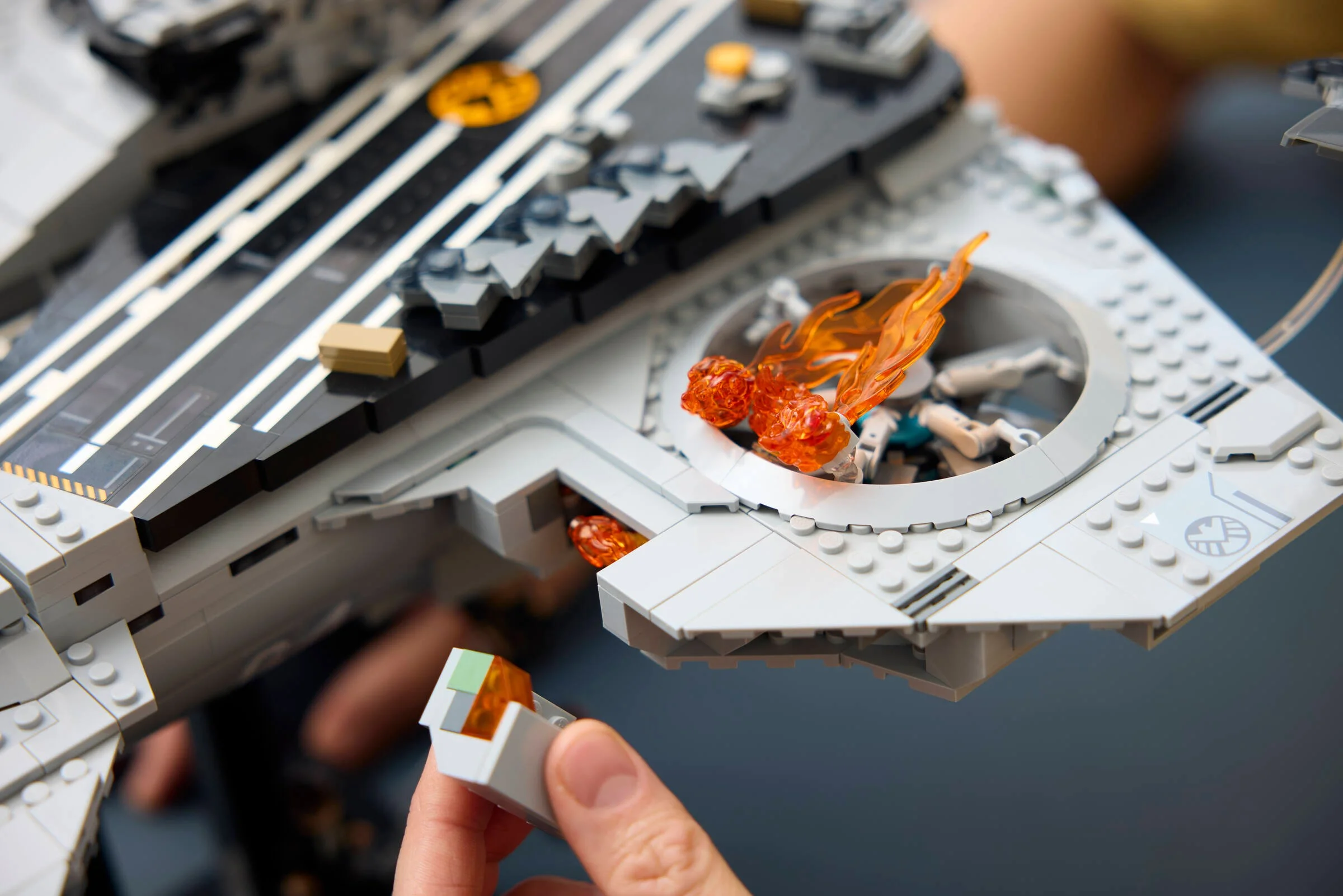 Prim-plan al Helicarrier S.H.I.E.L.D., detaliind zone de avarie cu efecte de flacără.