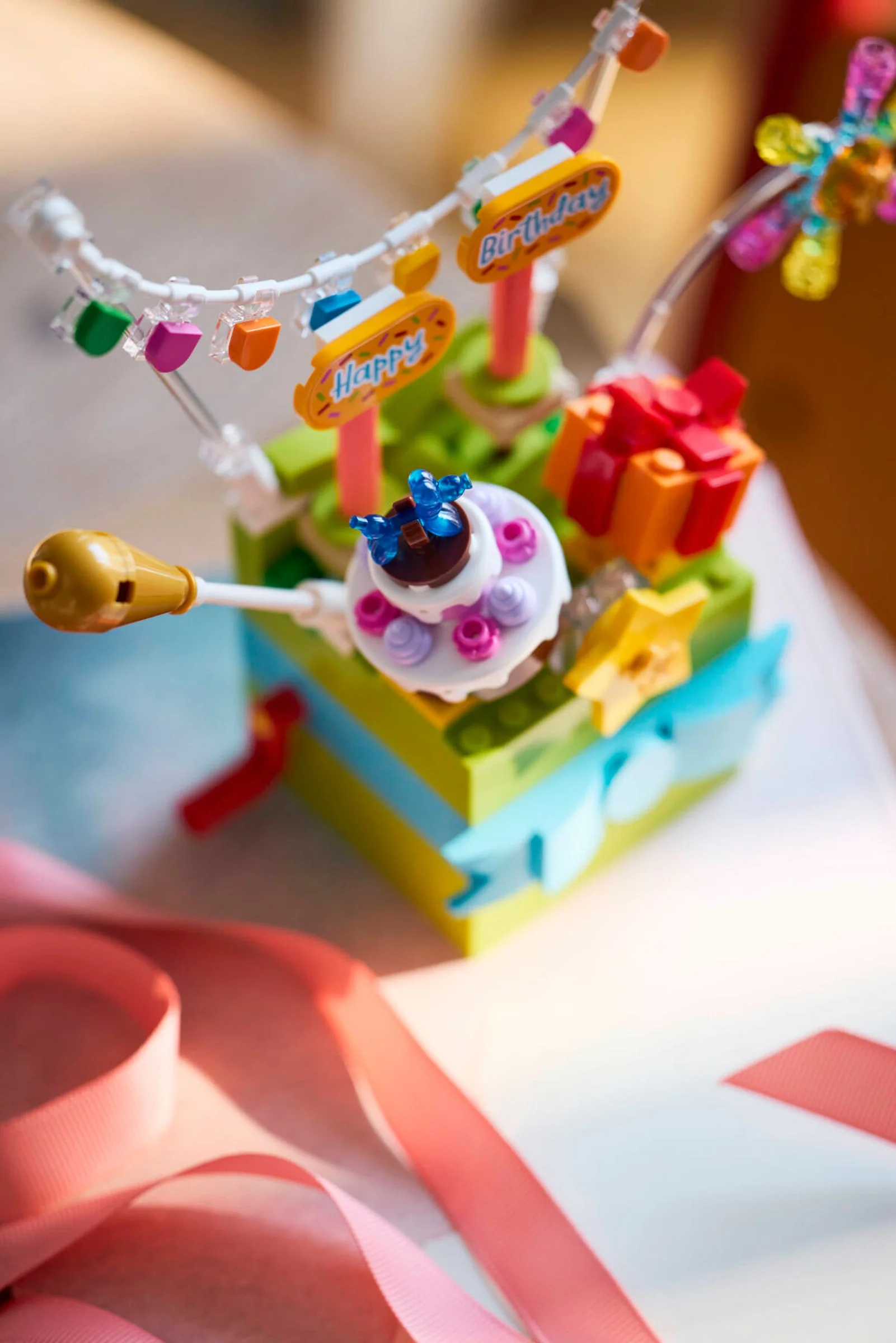 Modelul LEGO Cutie de Cadou Festivă (40871) cu tort, cadou și decorațiuni de petrecere.