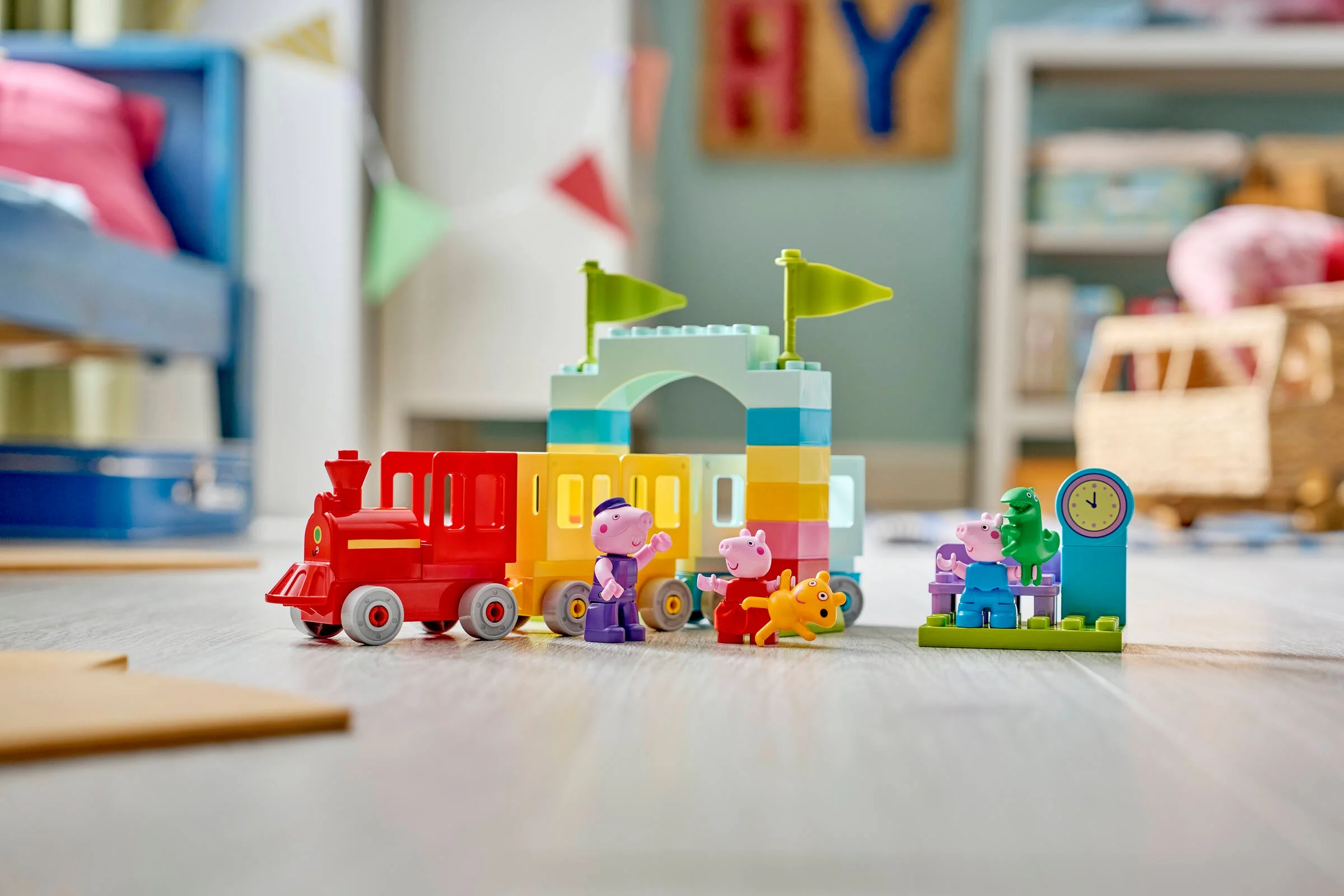 Set LEGO Duplo 10466 cu trenul și figurinele Peppa Pig, prezentat într-o scenă de joacă colorată.