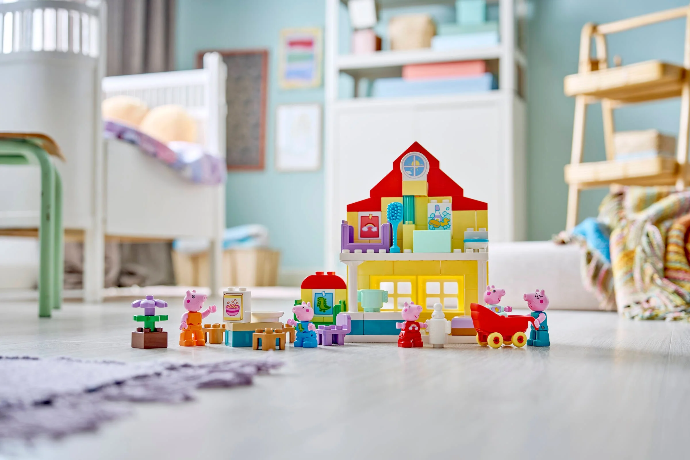 Casa Duplo 10467, cu personaje Peppa Pig, mobilier și detalii interactive, pe un fundal colorat.