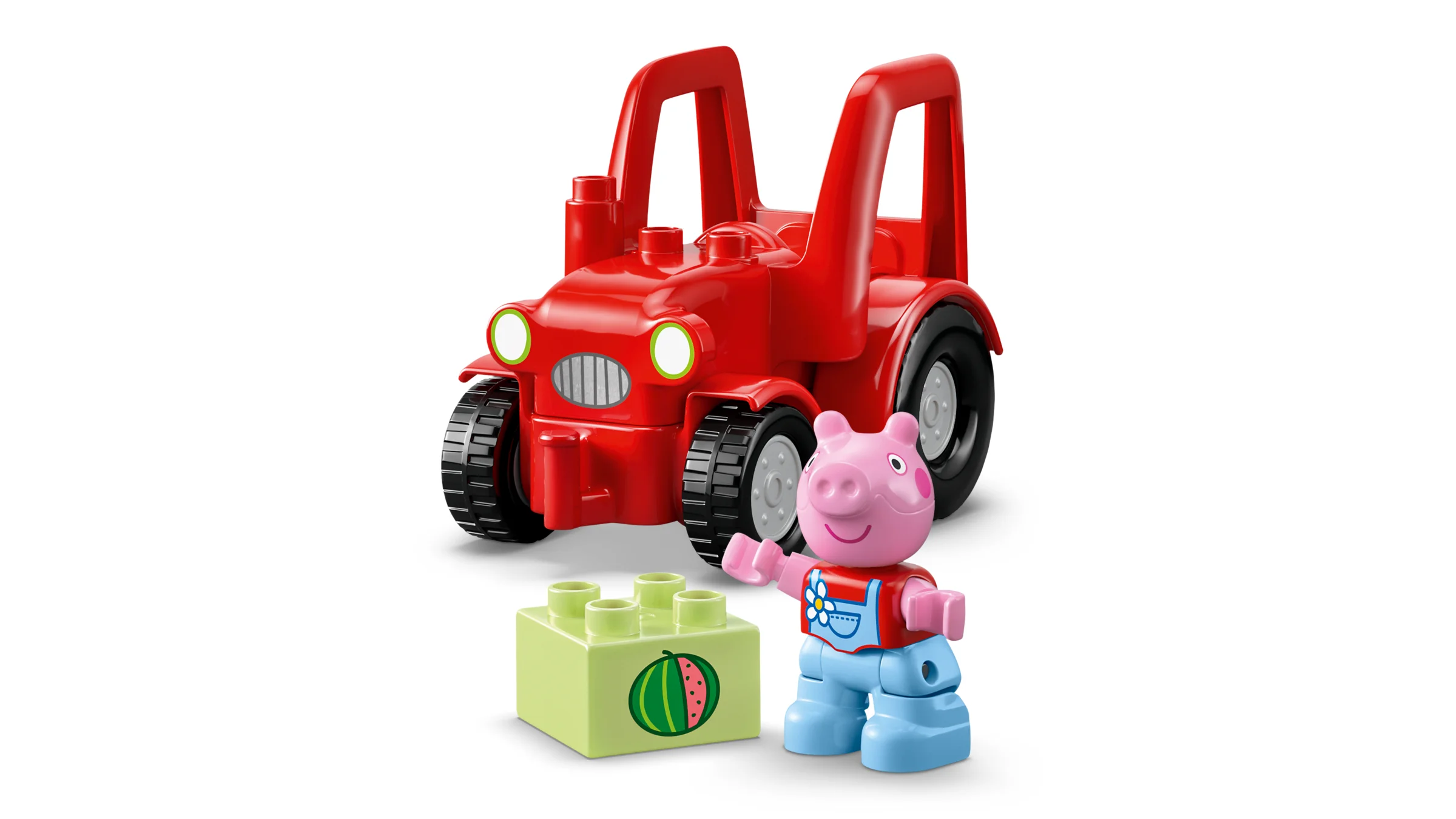 Imagine cu tractorul roșu și o minifigurină Duplo Peppa Pig lângă un bloc verde cu un pepene.