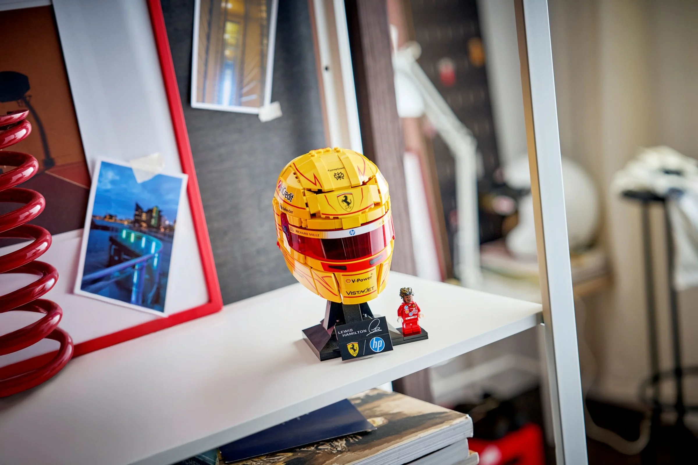 Casca Ferrari HP Lewis Hamilton LEGO, galbenă, pe un raft, cu minifigurină. 
