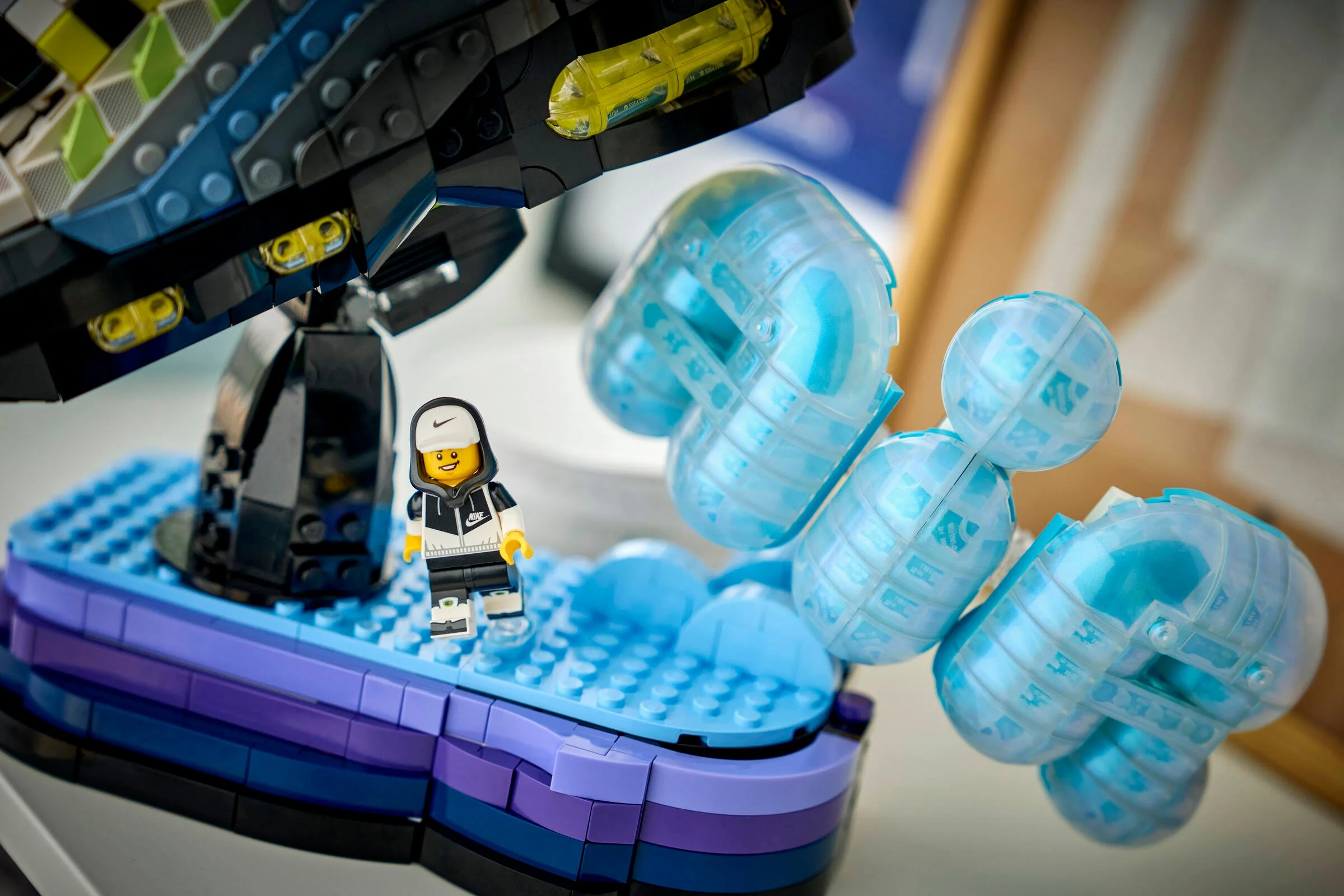 Prezentare a modelului LEGO Nike Air Max 95, cu minifigurină și detalii ale construcției.