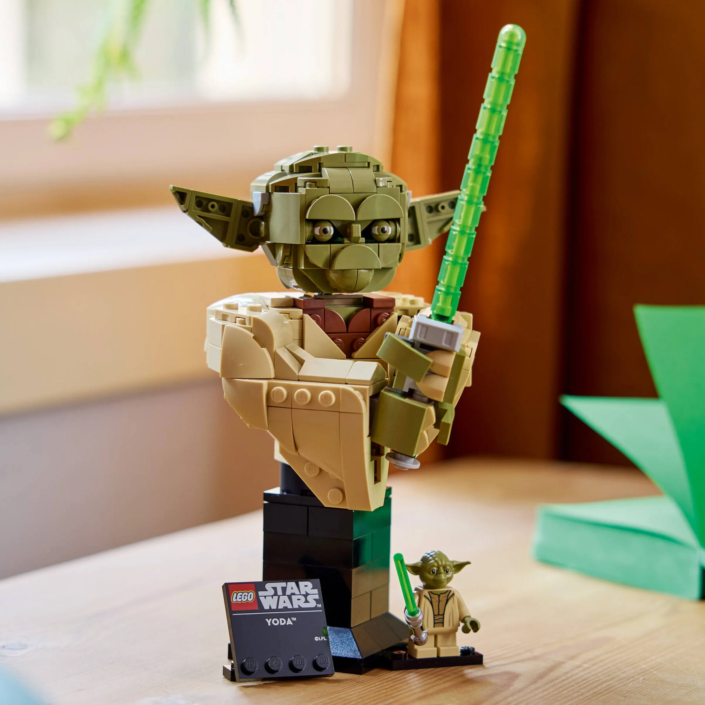 Imagine cu bustul Yoda LEGO, cu minifigurina și plăcuța informativă. O piesă de colecție Star Wars.