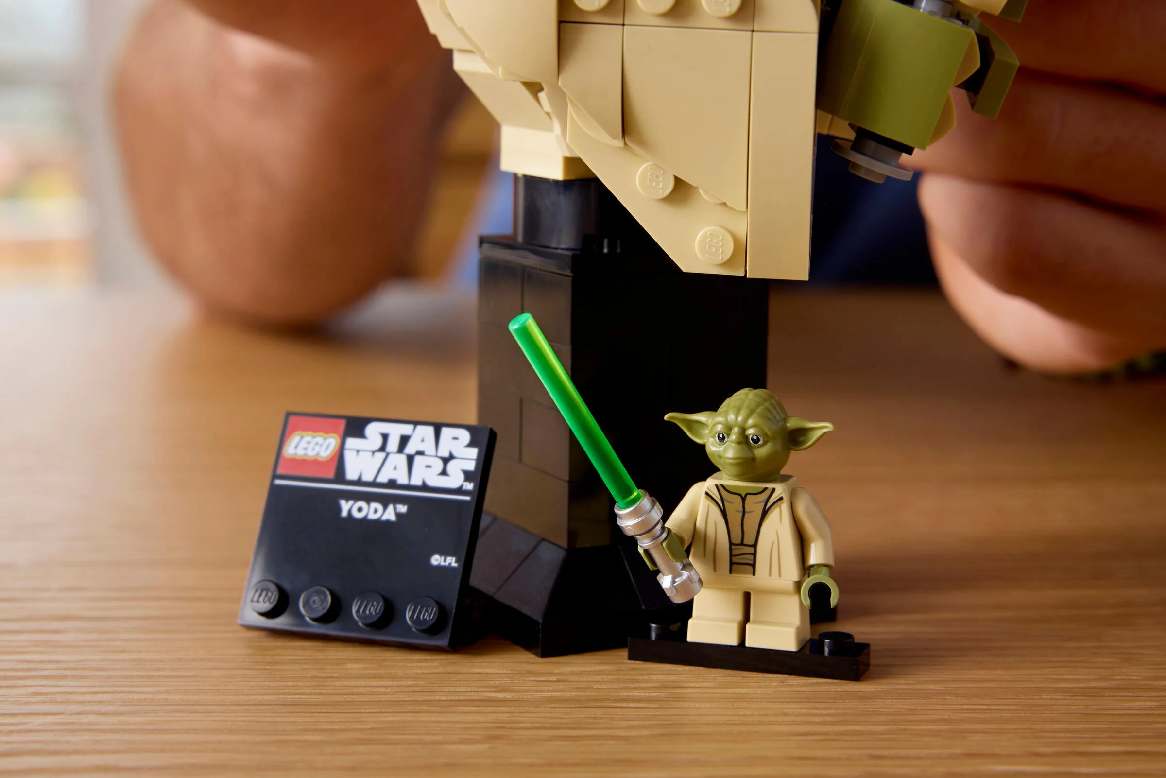 Imagine cu bustul Yoda LEGO Star Wars și minifigurina Yoda, cu detalii precise.