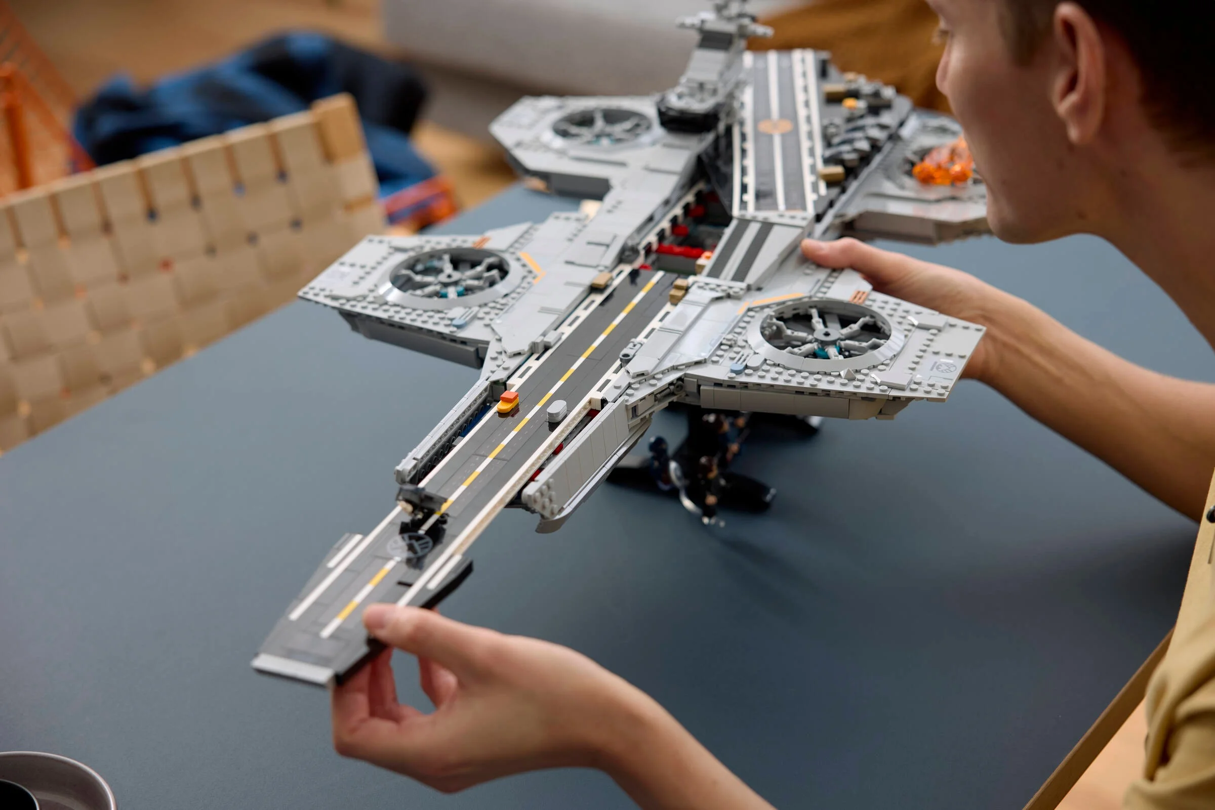 O persoană ține Helicarrier-ul S.H.I.E.L.D. construit din LEGO, admirând detaliile.