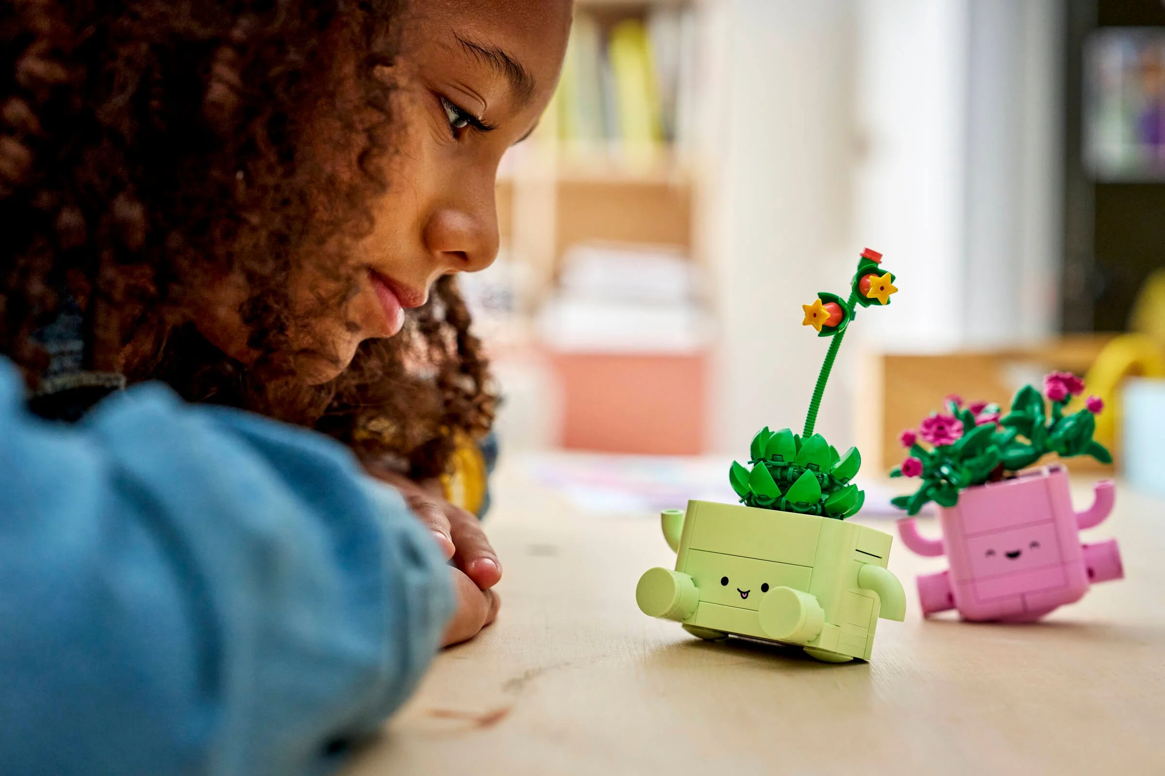 O fată admiră plantele LEGO Rocking. Drăguț și educativ, perfect pentru copii.