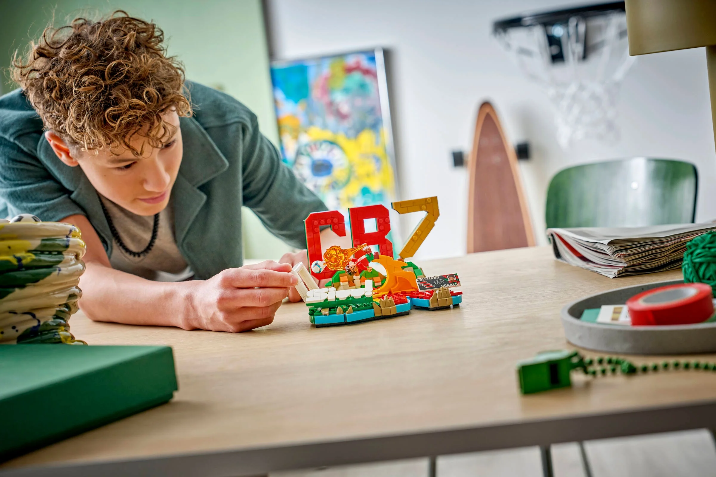 Un tânăr construiește setul LEGO Cristiano Ronaldo, concentrat pe asamblare. Acțiune, pasiune, distracție!