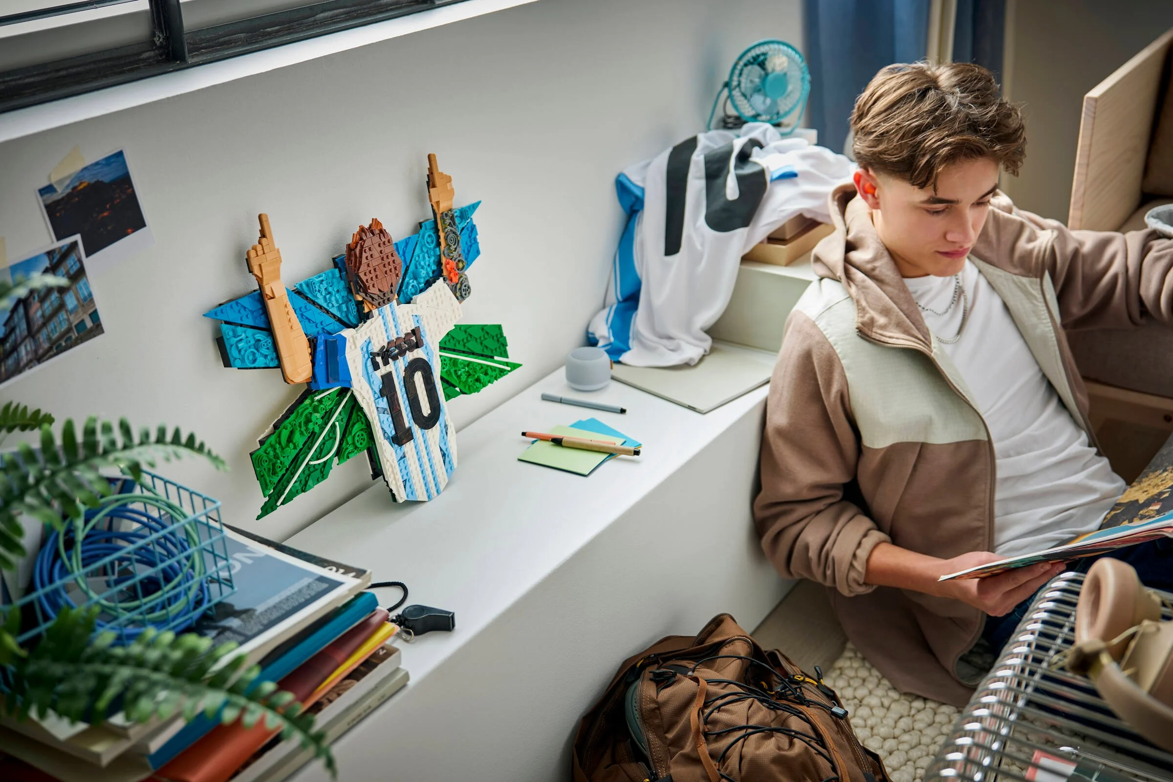Un model LEGO Messi pe perete, într-o cameră de adolescent, cu o atmosferă relaxată.