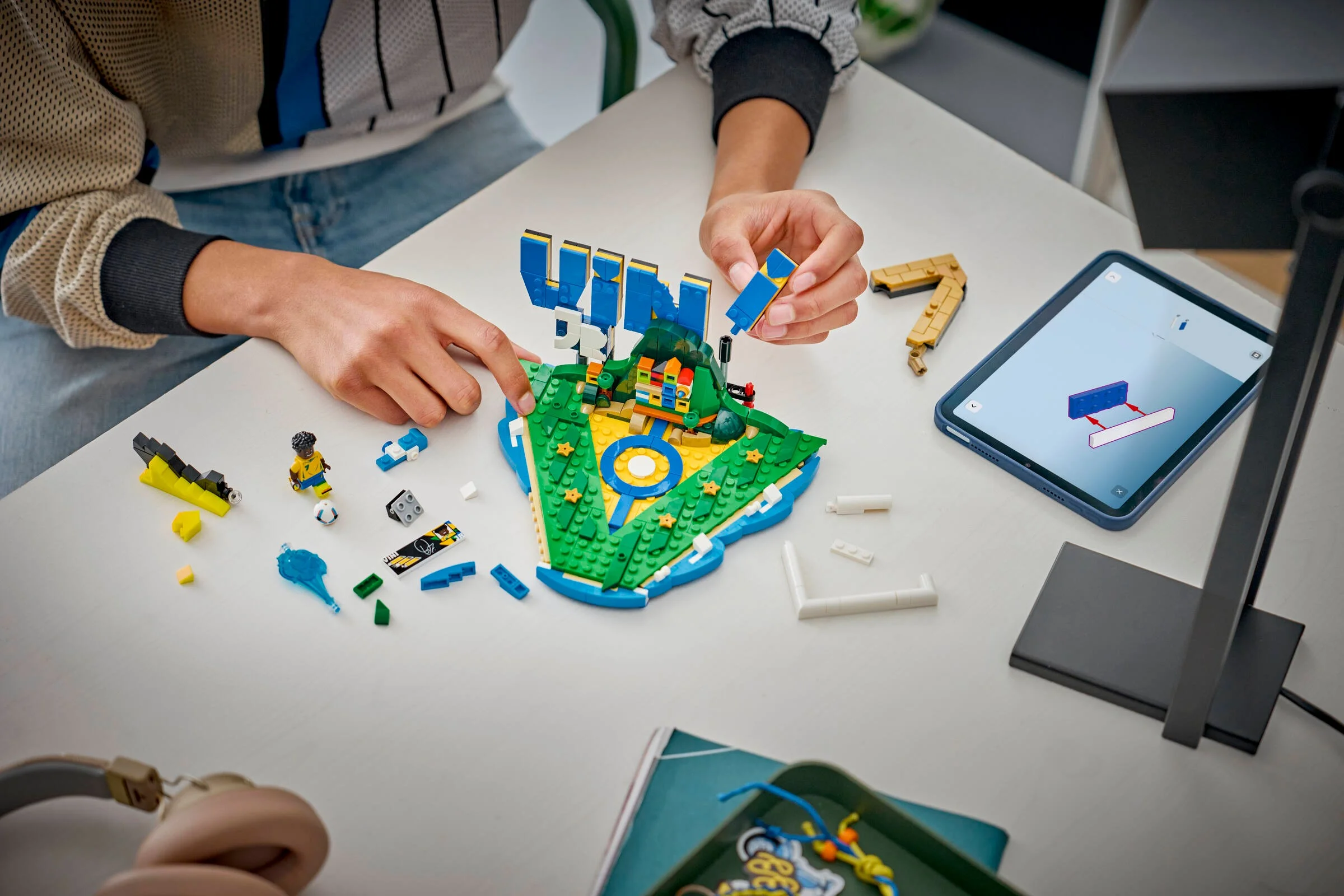 Construirea machetei LEGO Vini Jr. cu instrucțiuni digitale pe tabletă.