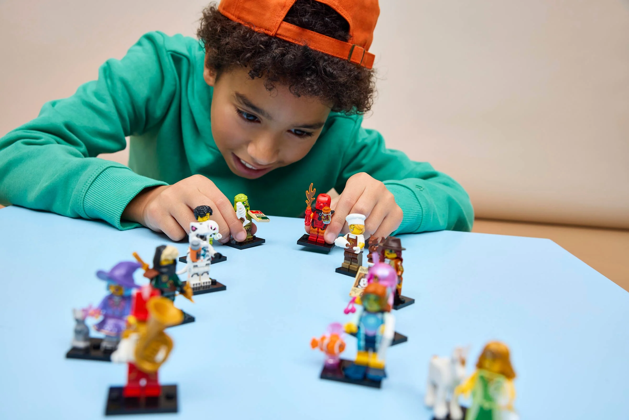 Copil se joacă cu minifigurinele LEGO din setul 71052, Robot T. rex. Colecție variată.
