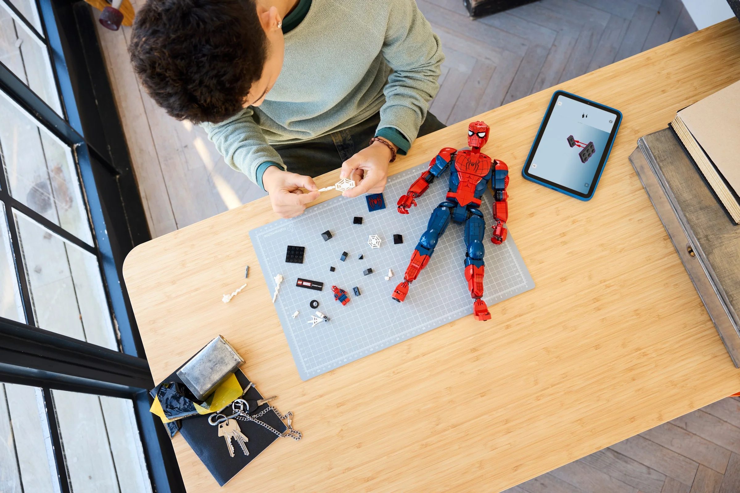 Construirea figurii LEGO Spider-Man. Imagine cu piese, figurină și instrucțiuni pe tabletă.