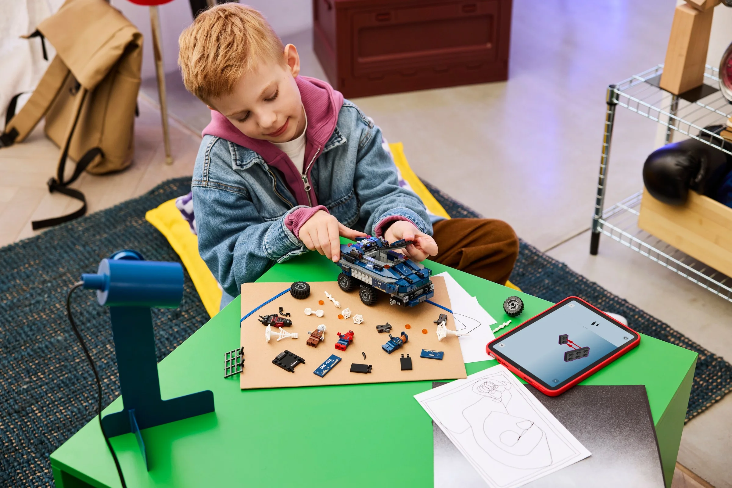 Băiat construind setul LEGO 76349, mașina de transport a închisorii Spider-Man.