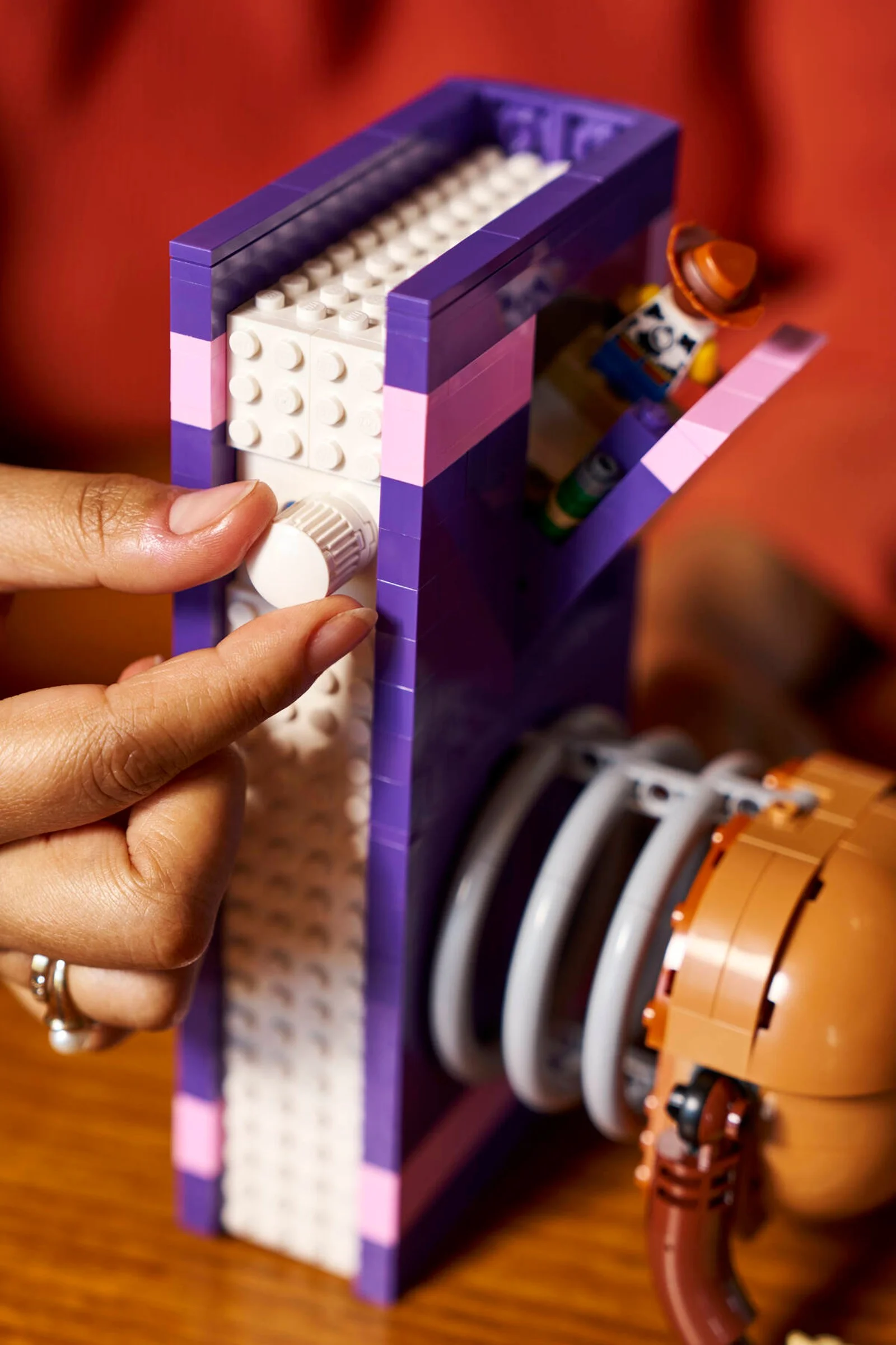 Un detaliu al setului LEGO Toy Story Slinky Dog Bookends, cu o mână ajustând un detaliu al cărții.