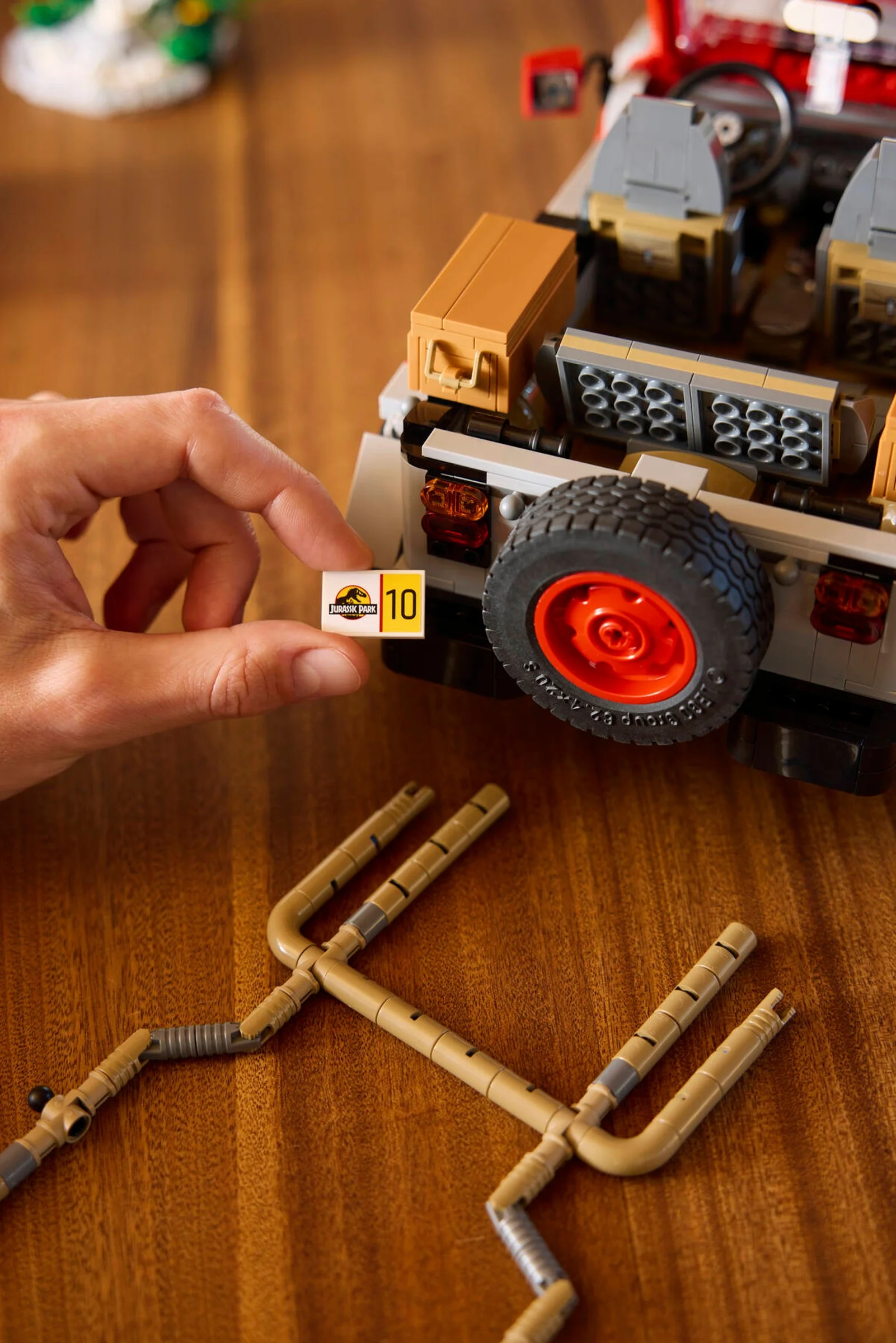 Prim plan cu detaliile Jeep-ului Jurassic Park, piesa cu numărul 10 și un accesoriu, ilustrând construcția.