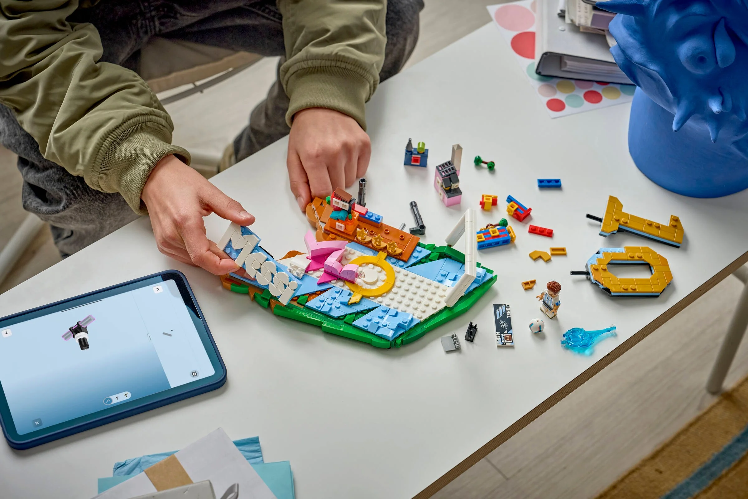 Construirea mozaicului LEGO Lionel Messi folosind o tabletă cu instrucțiuni digitale.
