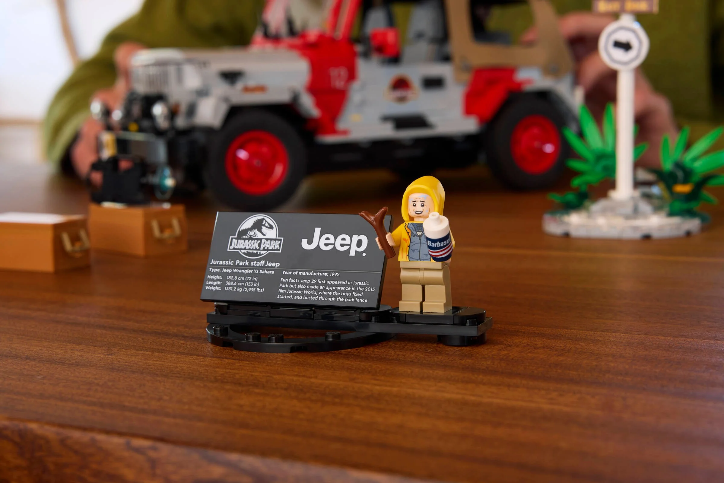 Prim plan cu minifigurina Dennis Nedry și plăcuța informativă Jeep, parte din setul Jurassic Park.