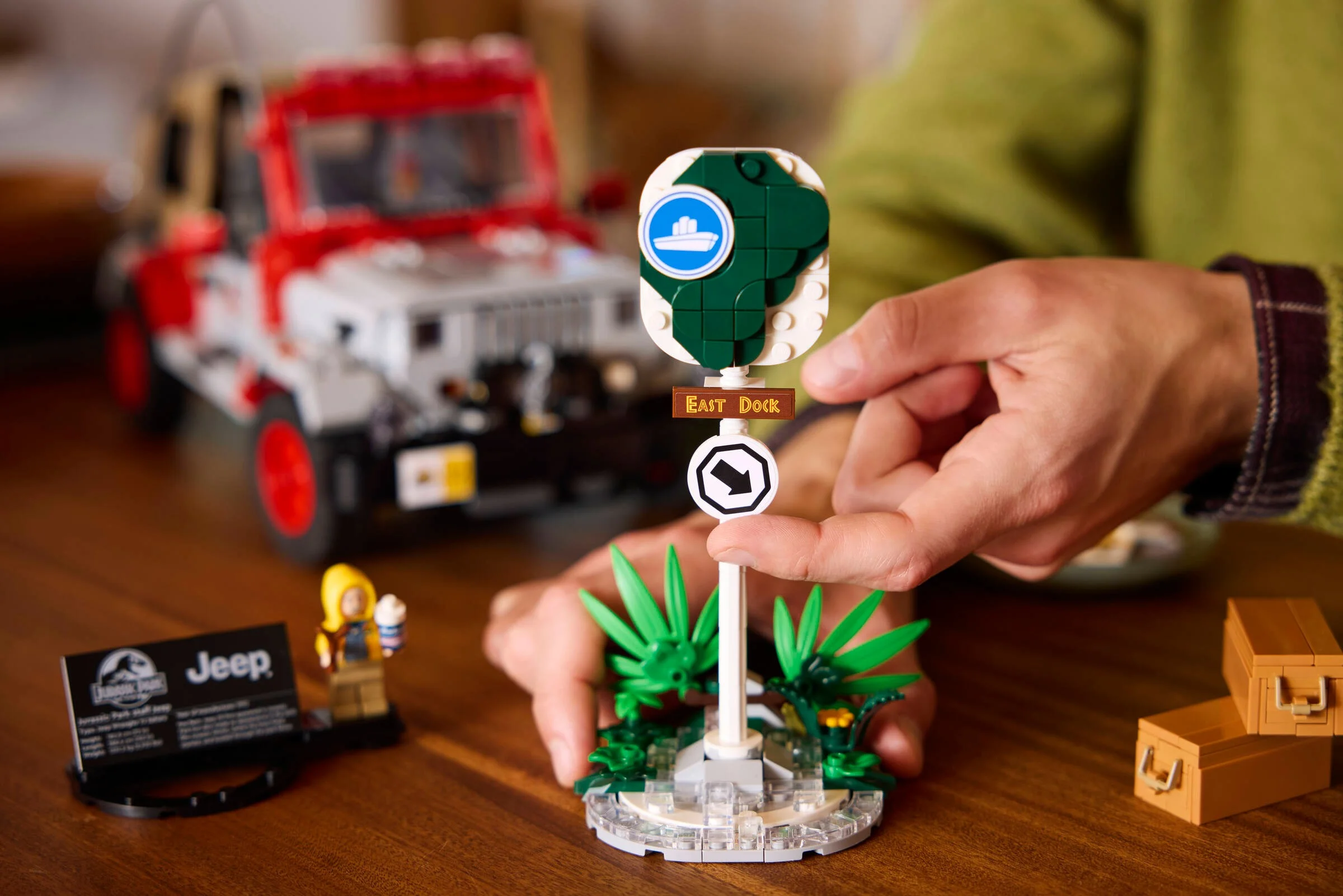Scenă cu Jeep Wrangler și indicatoare Jurassic Park. Detaliu: mâini interacționând cu indicatoarele.