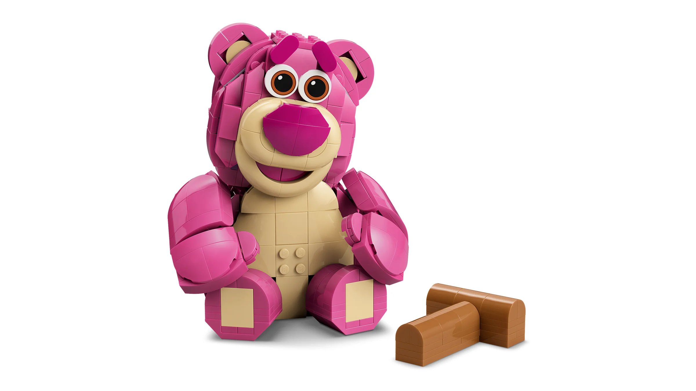 Imagine cu Lotso LEGO, un urs roz zâmbitor, cu butuci maro alături. Modelul finalizat.